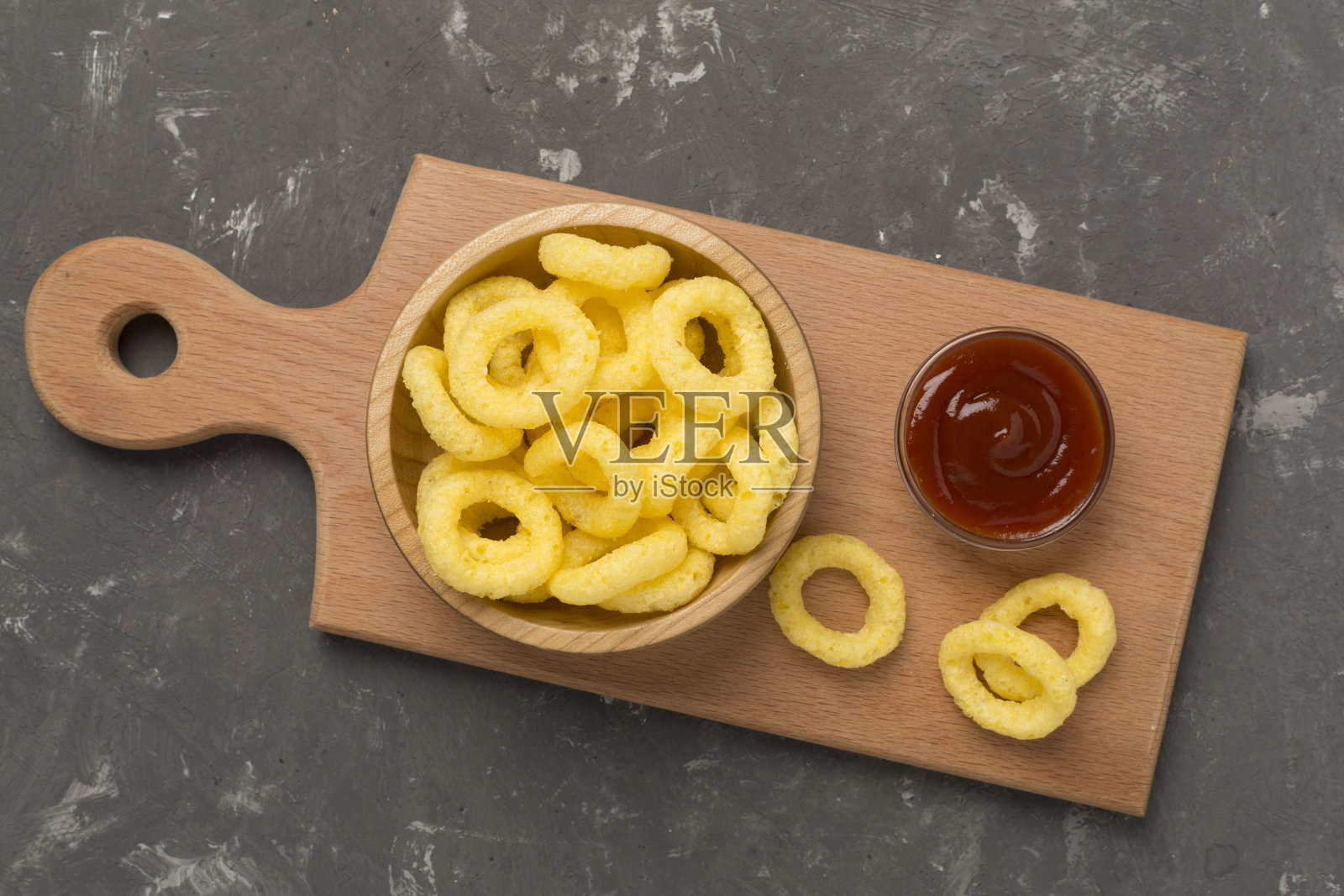 混凝土背景上的玉米圈薯片，俯视图照片摄影图片