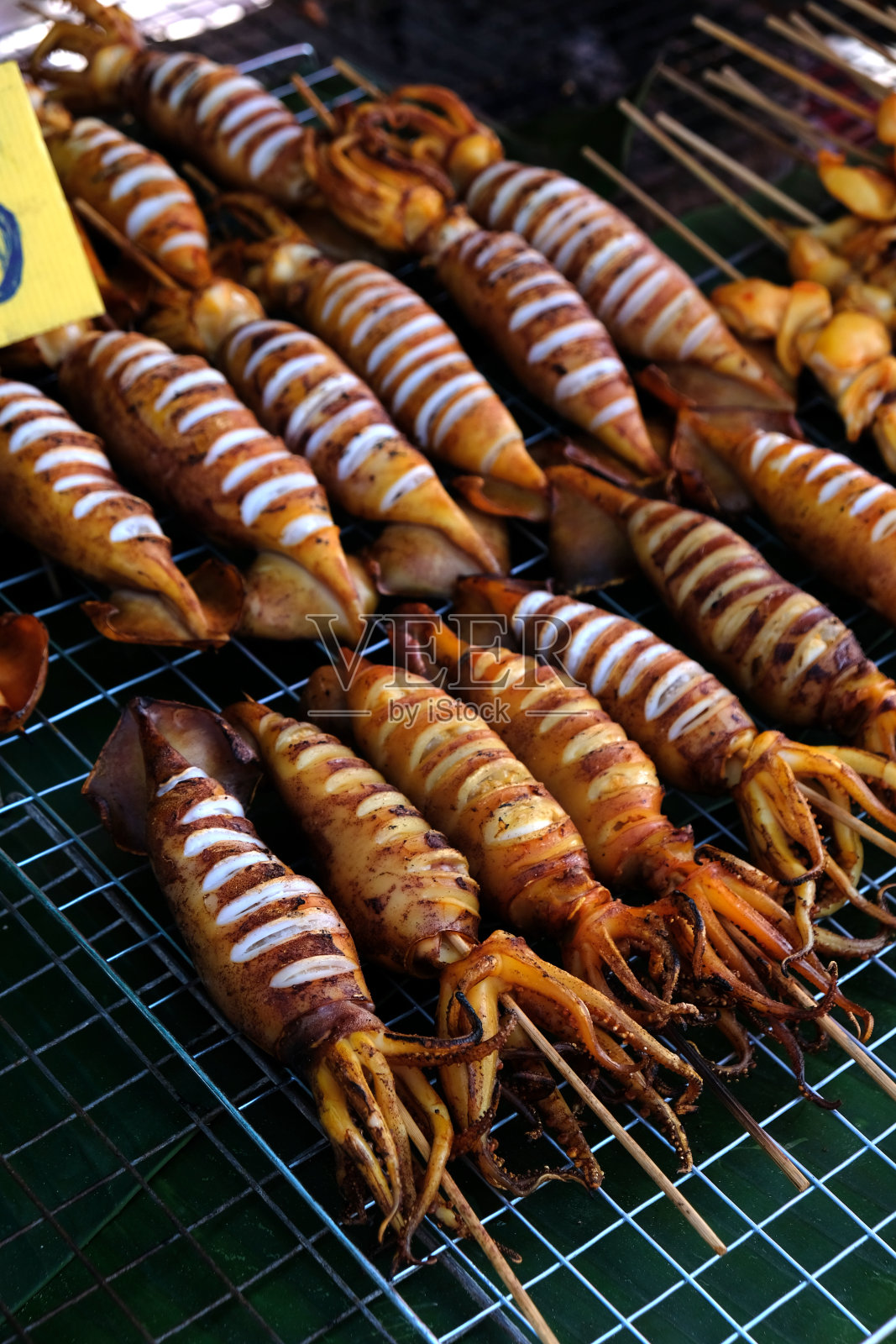 烤鱿鱼躺在金属格栅上照片摄影图片