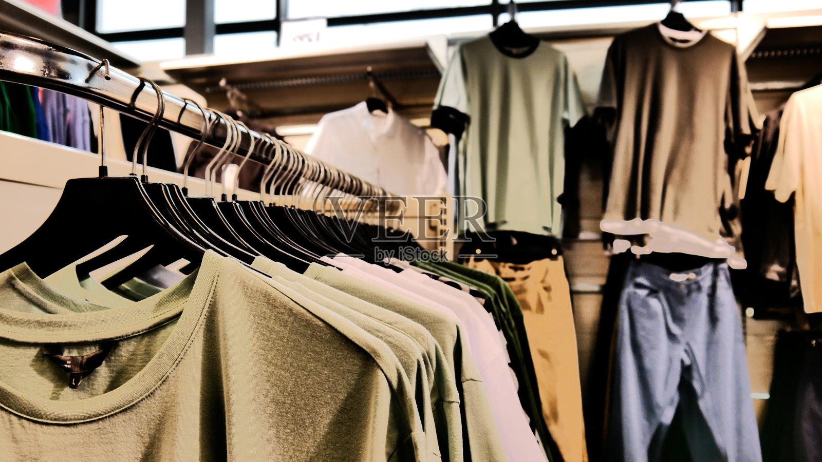 挂在青年服装店货架上的t恤系列特写照片摄影图片