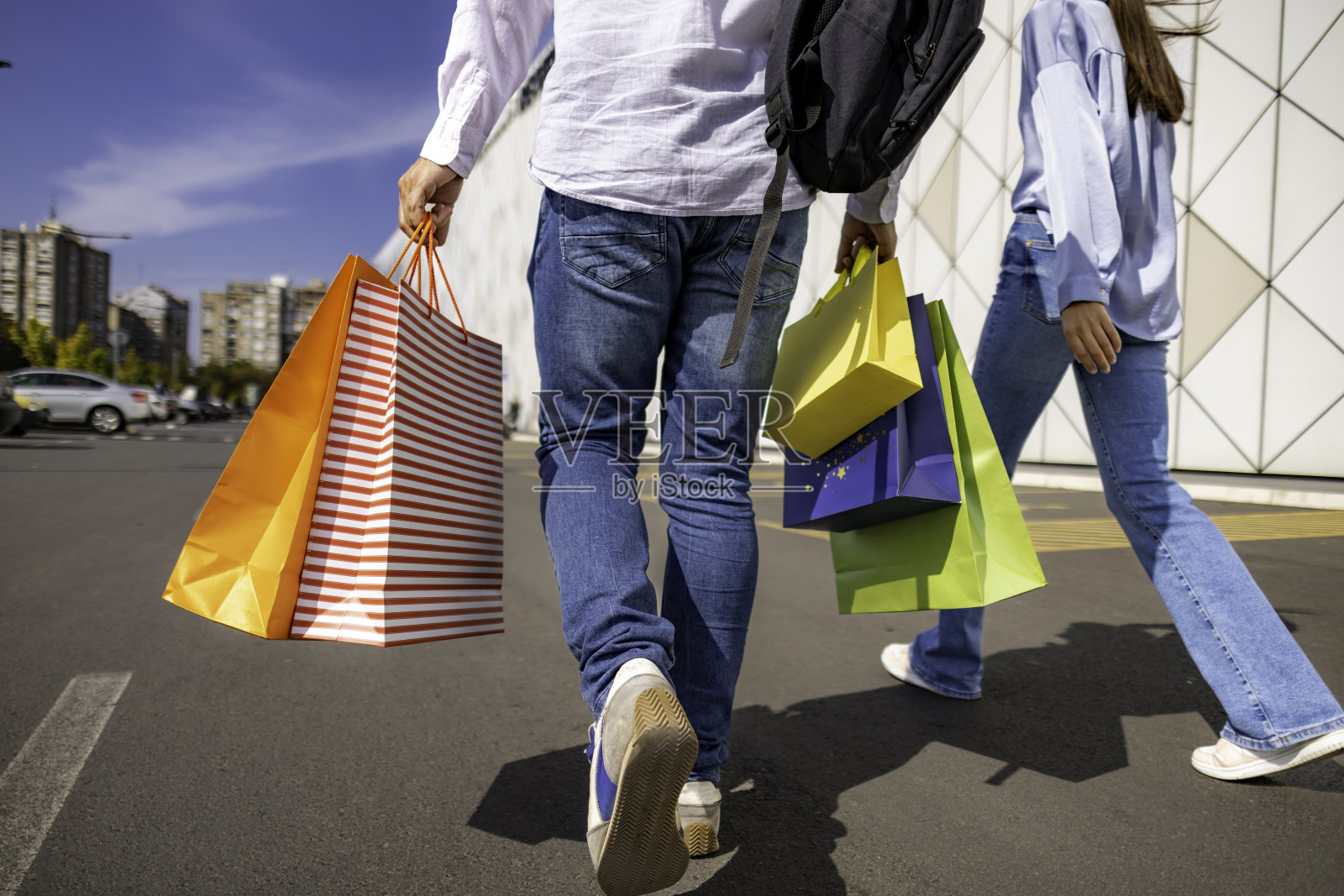 认不出来的一对，走在购物中心附近，两人都提着购物袋照片摄影图片