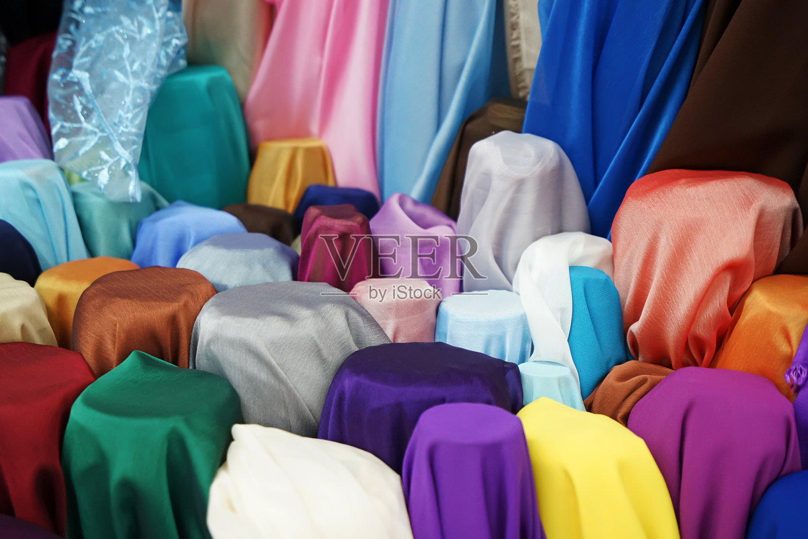 在“KAD LUANG”的纺织品商店，堆叠彩色织物卷。照片摄影图片