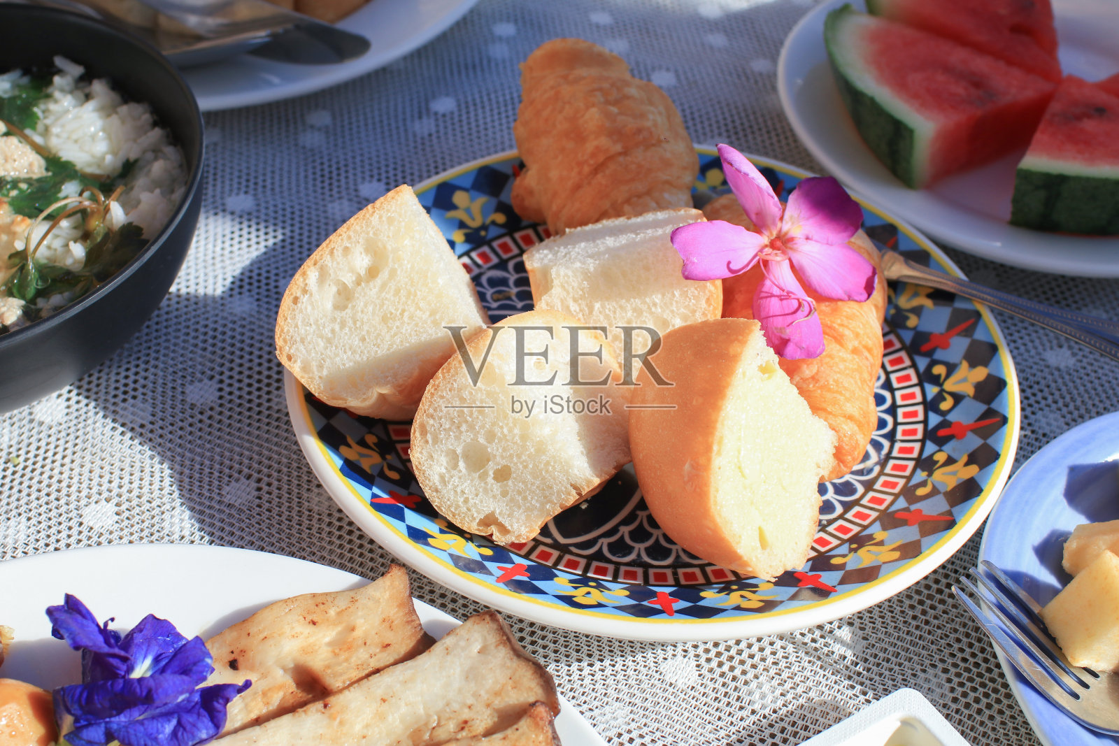 户外餐桌上的紫色花朵早餐面包，浪漫假日早午餐照片摄影图片