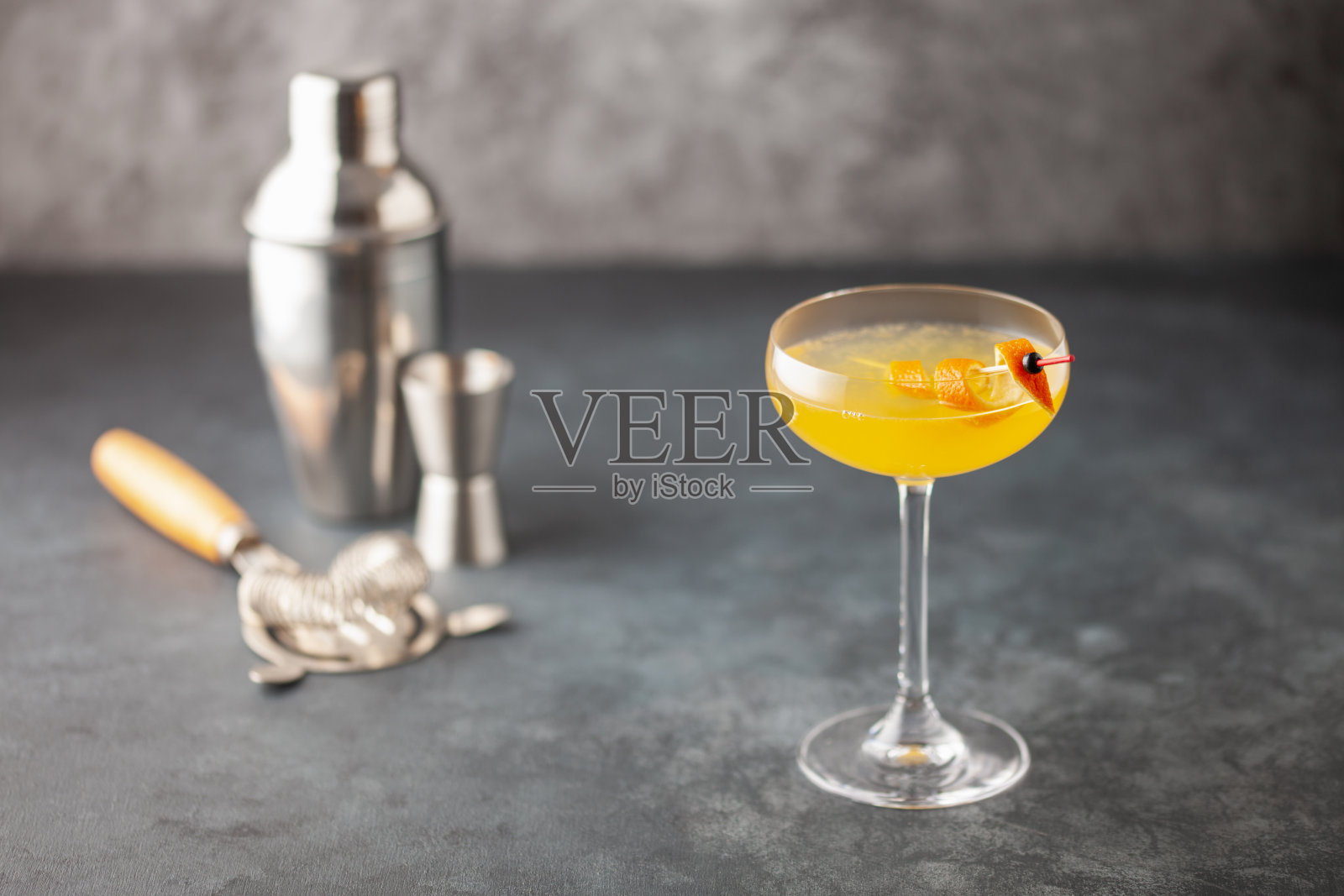 酒死人复活2号鸡尾酒与杜松子酒和柠檬在鸡尾酒杯。酒精饮料和酒吧工具。照片摄影图片