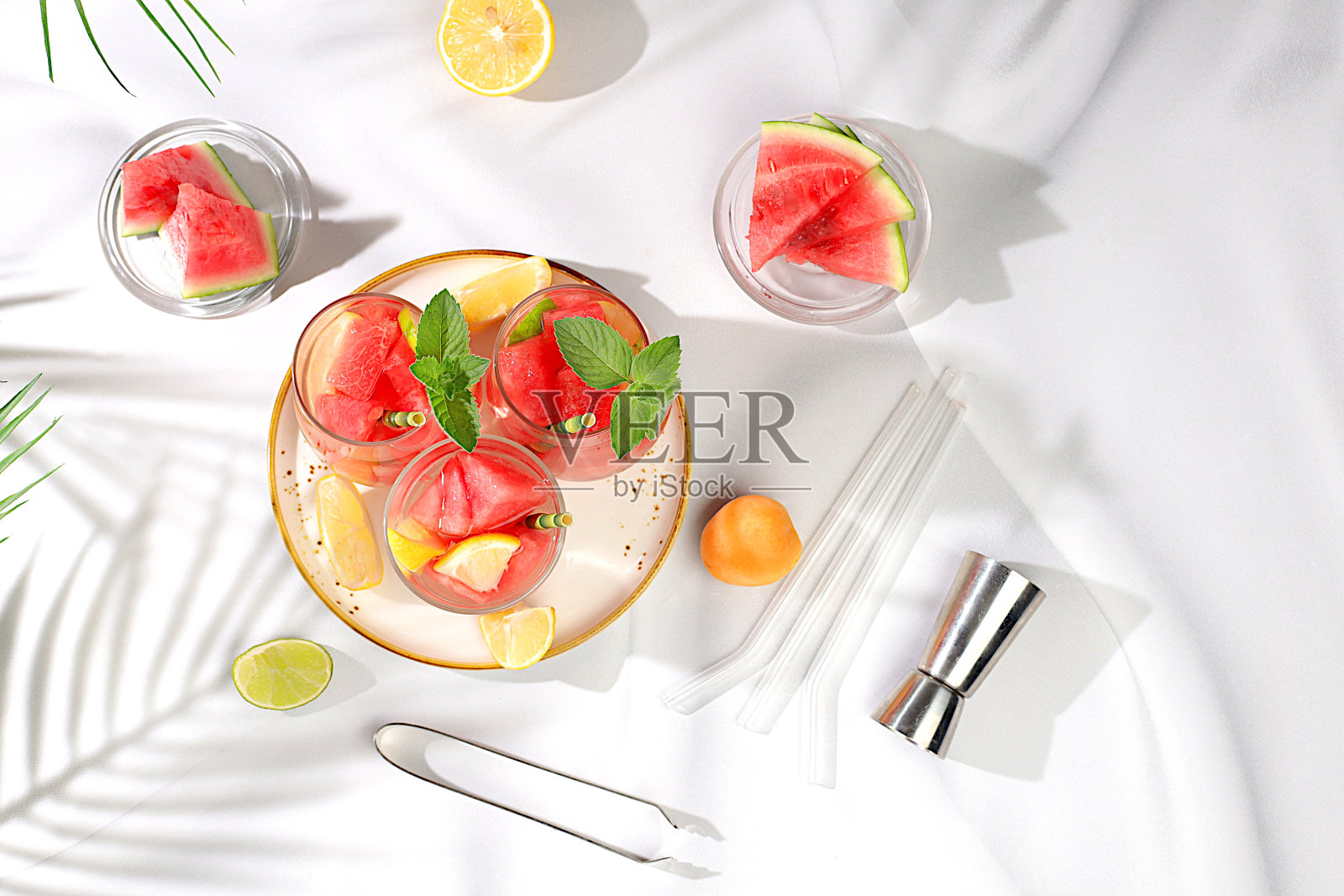 冰镇自制柠檬水或鸡尾酒，薄荷，西瓜和水果在阳光明媚的桌子上，清爽的夏季饮料配方，排毒饮食和减肥概念，餐厅菜单，照片摄影图片