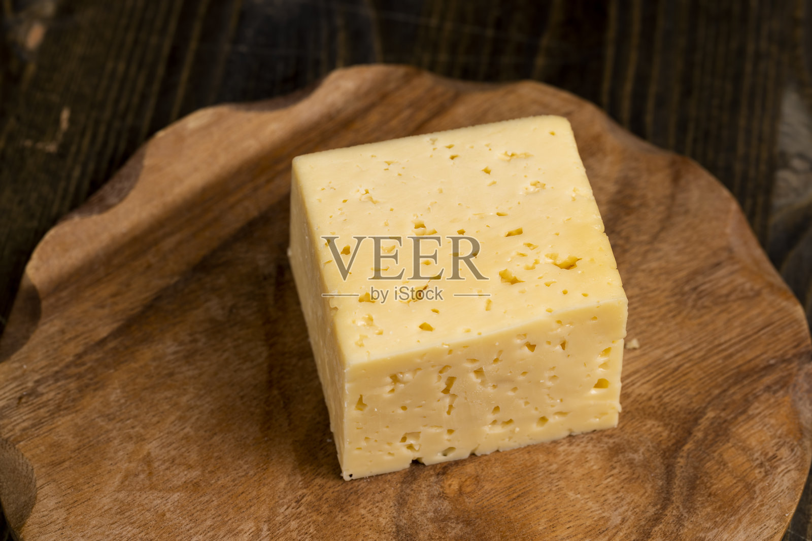 桌上有一块有洞的奶酪照片摄影图片