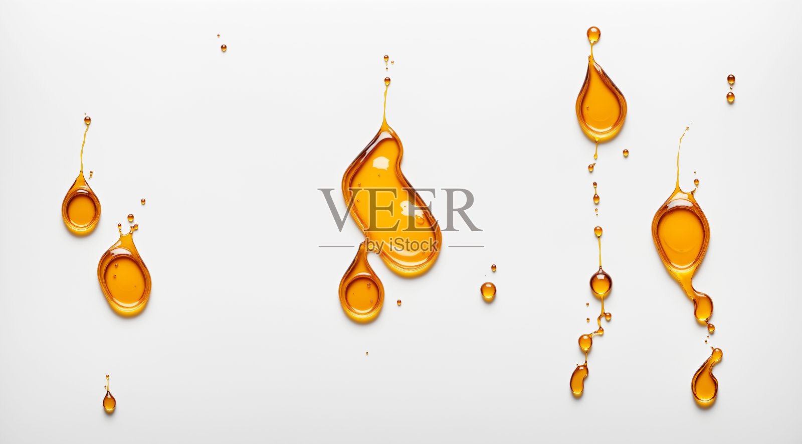 一张特写照片，金色的蜂蜜滴在白色的表面上。这种液体创造出有趣的图案和纹理。三维渲染照片摄影图片