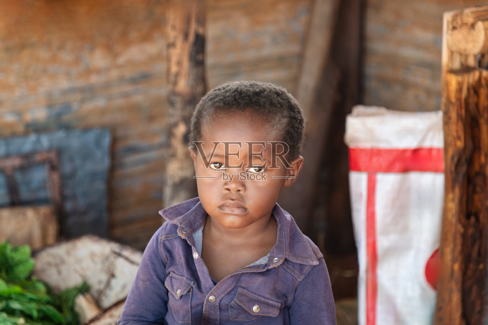 一个富有表情的非洲孤儿肖像，贫穷简陋的背景照片摄影图片