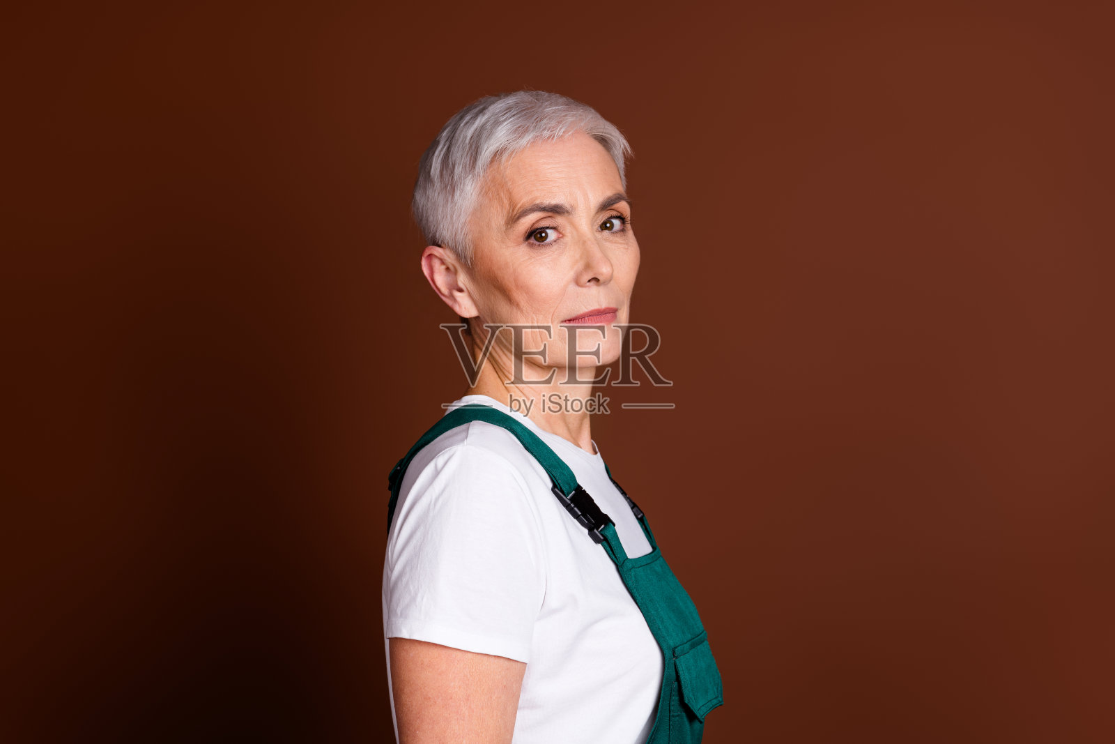 照片自信迷人可爱的高级女员工穿着制服孤立的棕色背景照片摄影图片