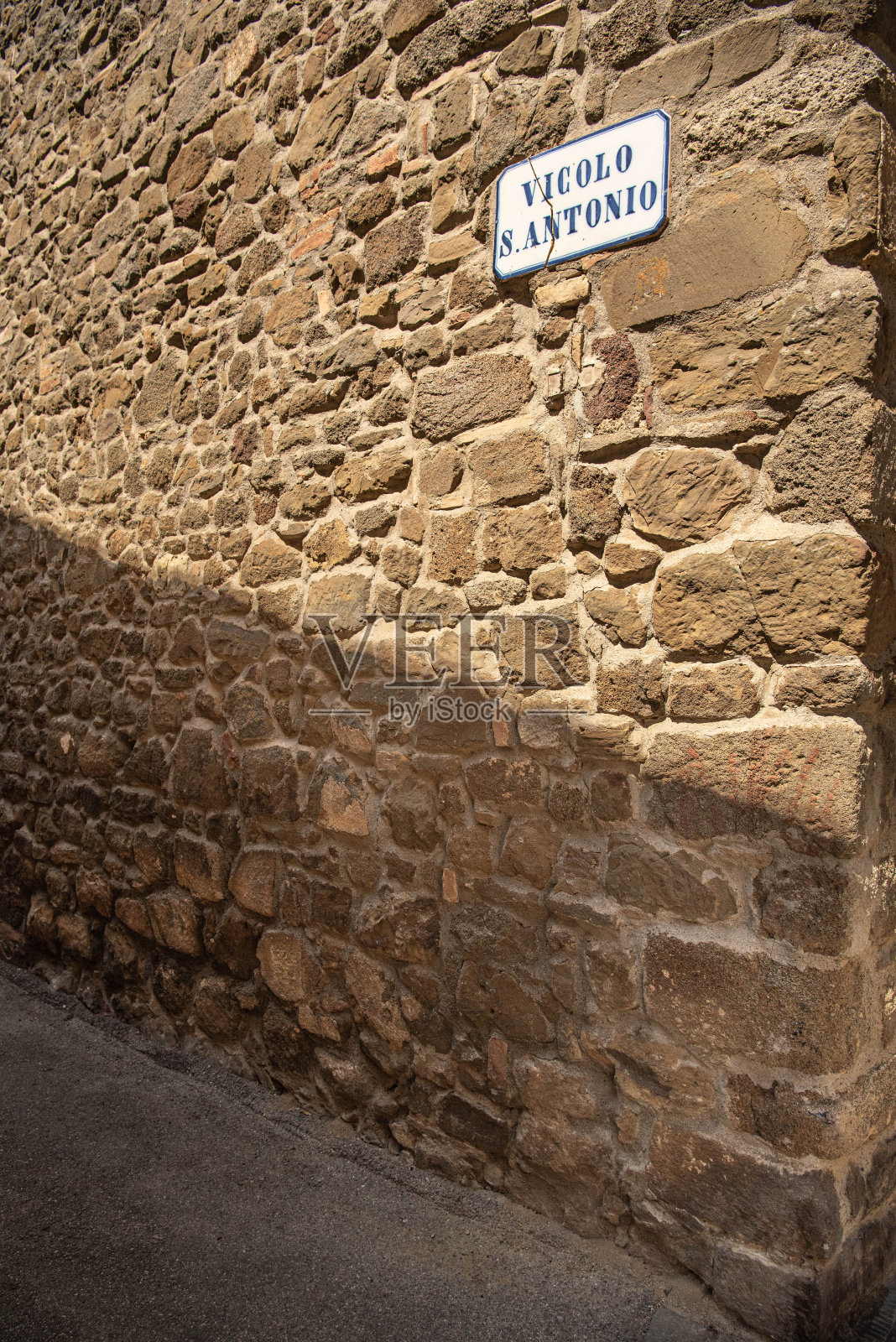 Vicolo S. Antonio在意大利托斯卡纳蒙塔奇诺的石墙上照片摄影图片