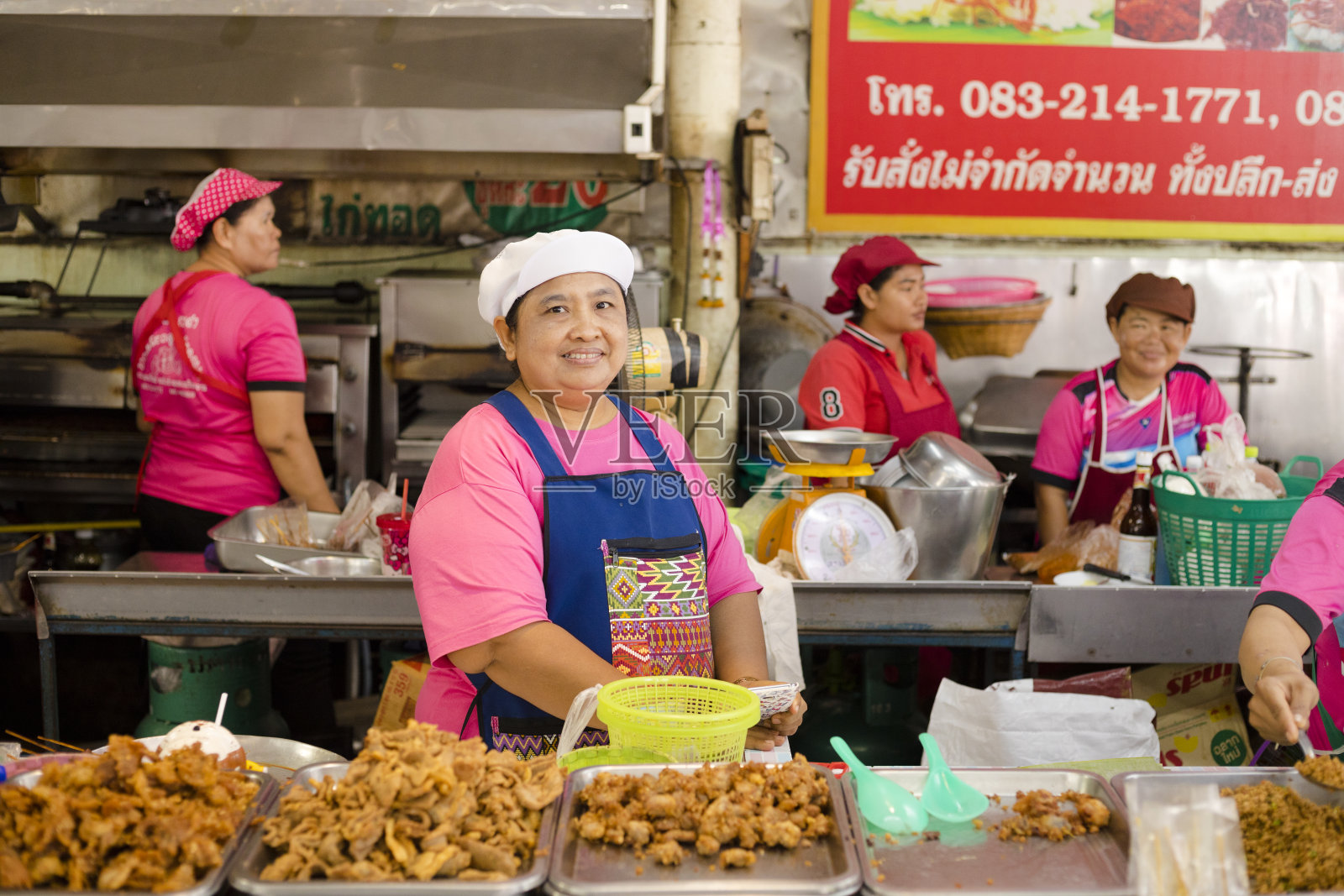 在市场摊位上卖油炸食品的泰国女商贩照片摄影图片