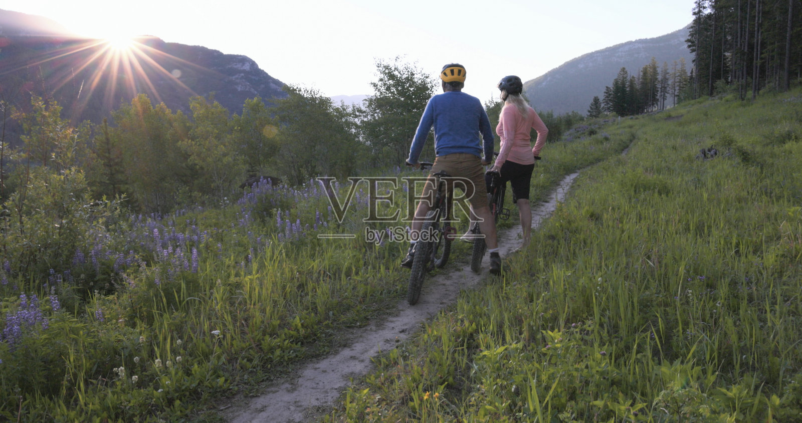 一对老年夫妇骑山地自行车探索高山草地照片摄影图片