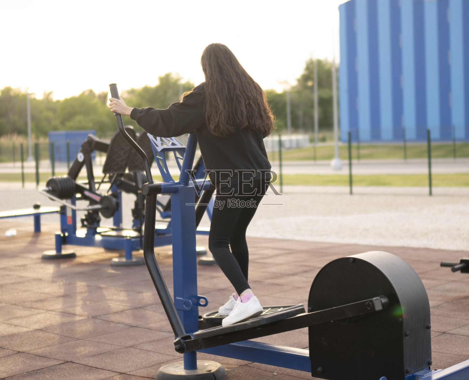 女运动员在室外椭圆机上进行腿部训练照片摄影图片