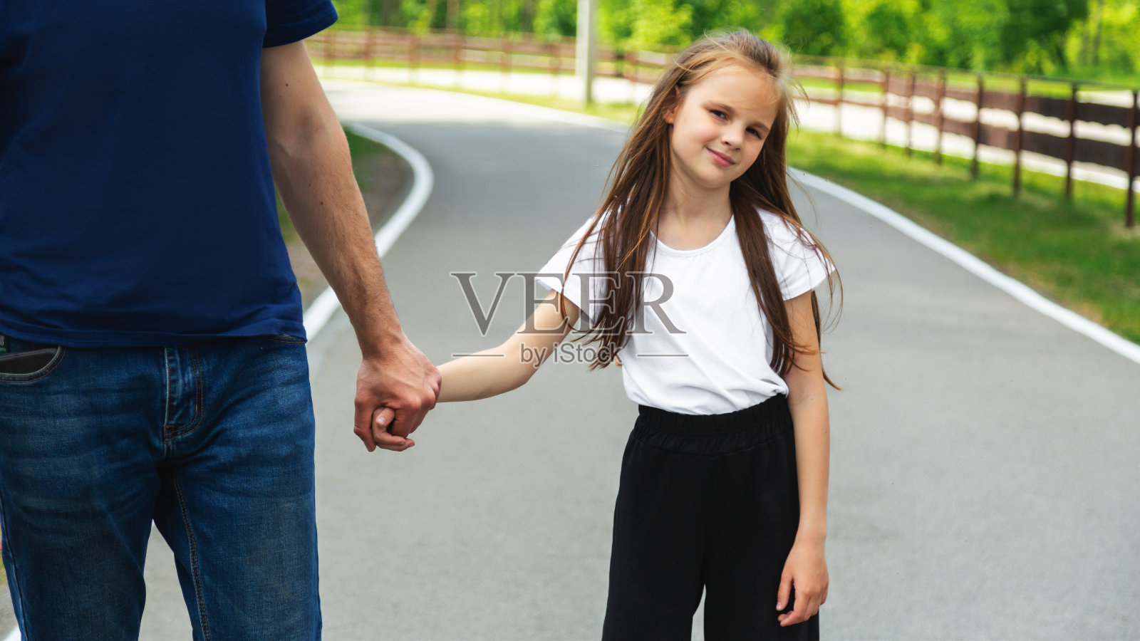 滑冰，学习，爸爸牵着孩子的手在公园教她。家庭，爱和爸爸帮助他年幼的女儿支持，平衡和照顾户外轮滑照片摄影图片