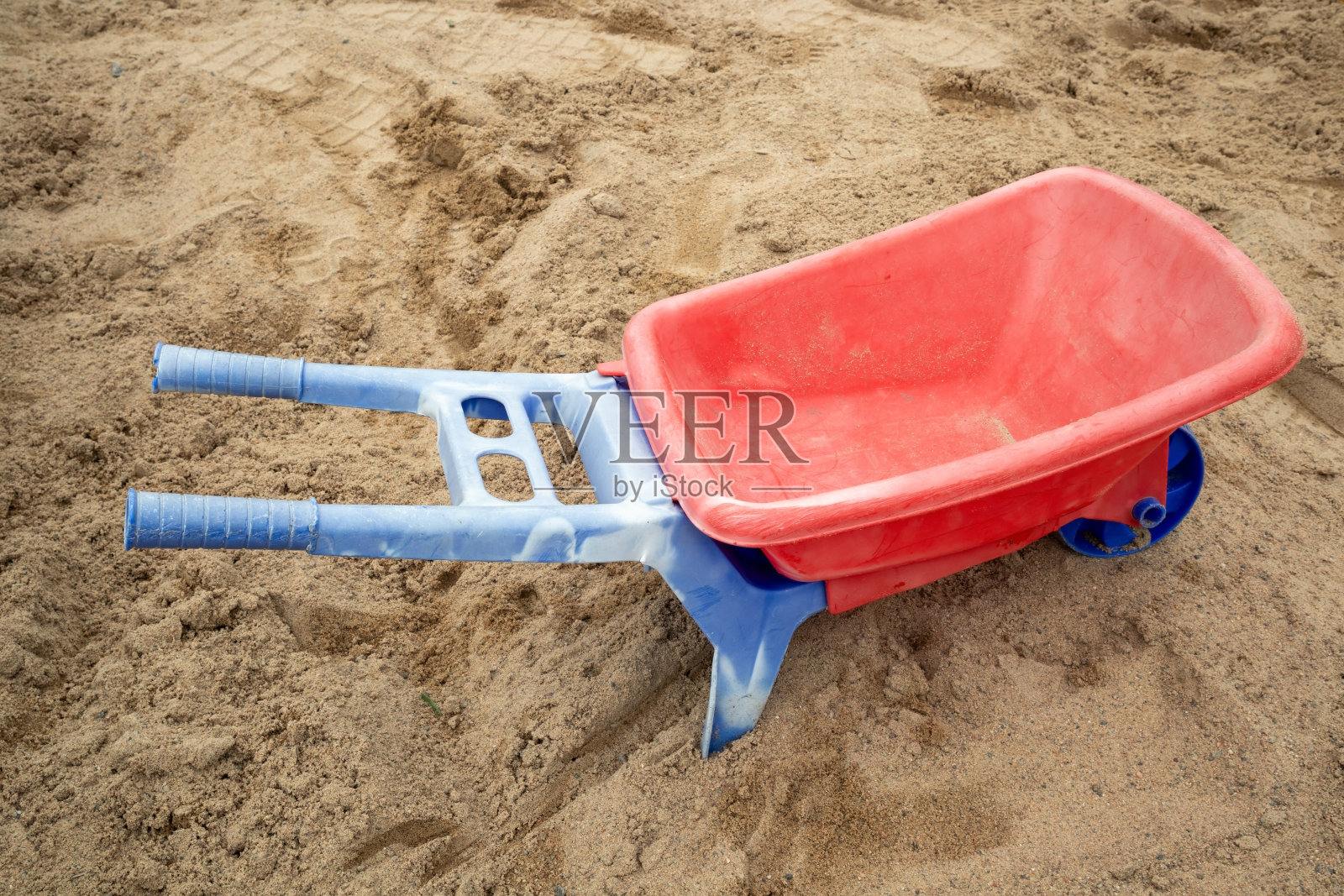 户外沙箱里的塑料玩具手推车照片摄影图片
