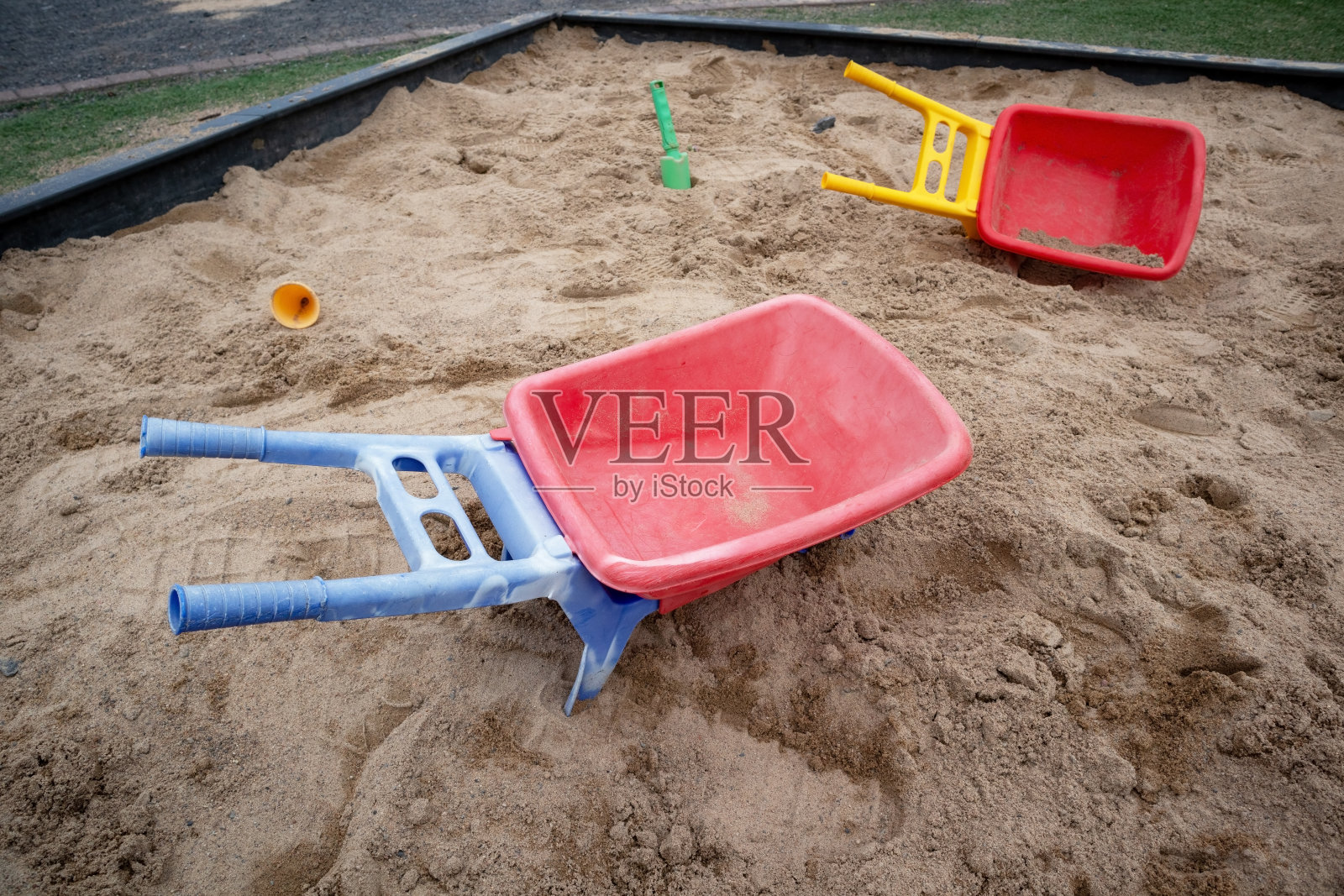 户外沙箱里的塑料玩具手推车照片摄影图片