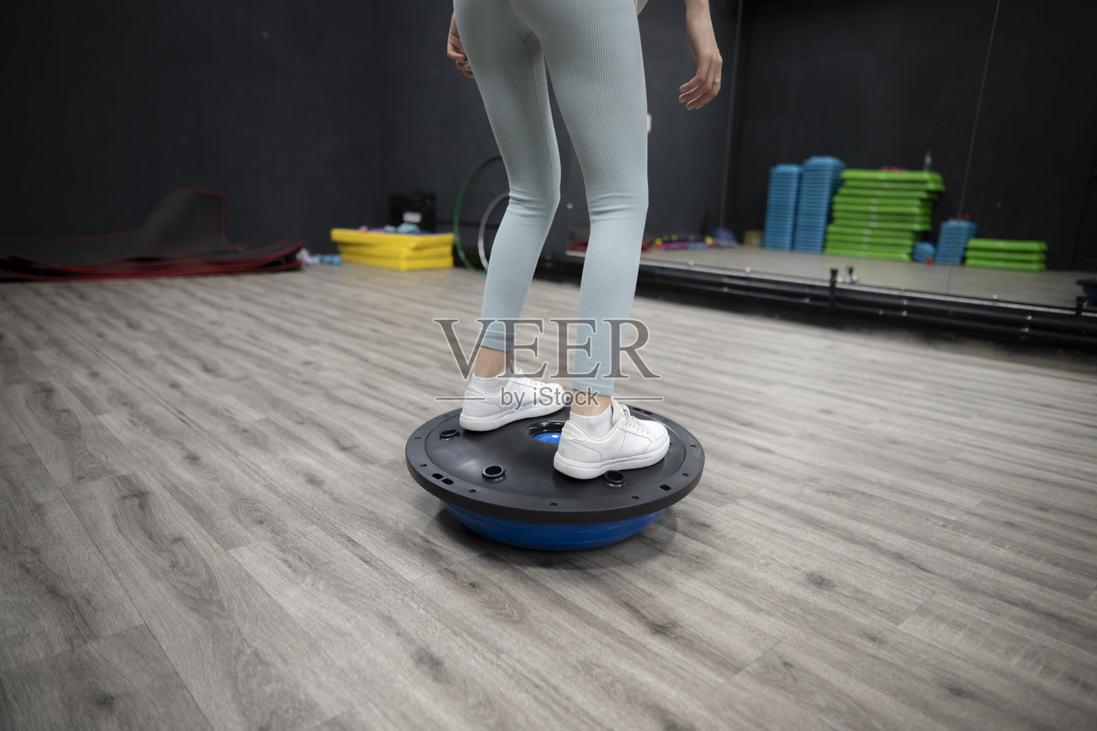 女运动员在健身房的蓝色运动圆盘上练习平衡照片摄影图片