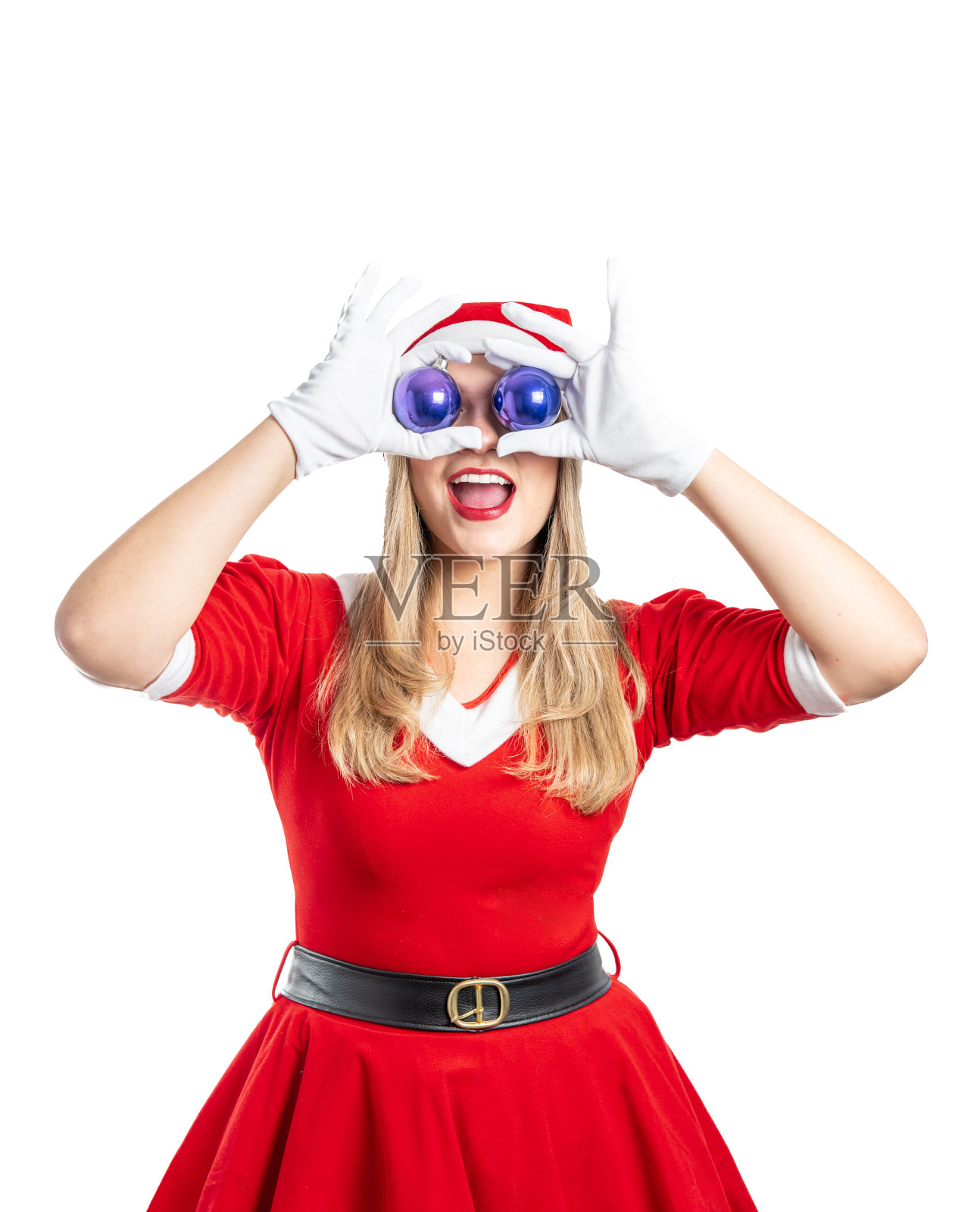 穿着圣诞老人服装的年轻金发女郎对着镜头微笑，眼睛里有两个圣诞球照片摄影图片