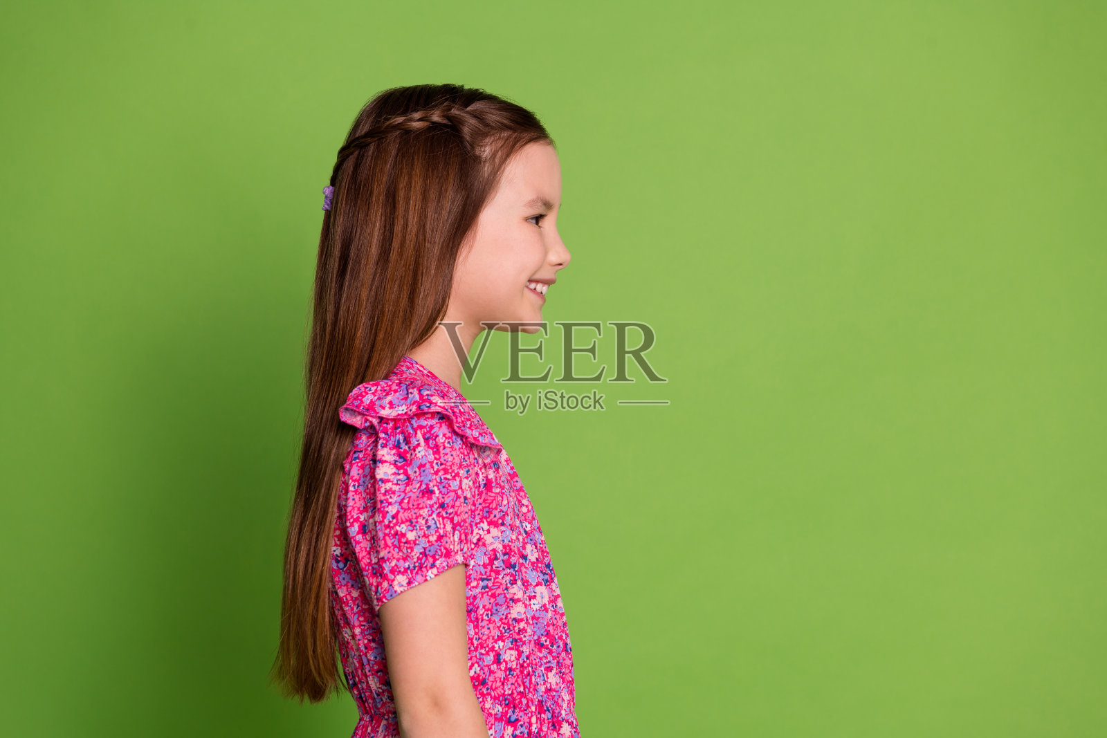 可爱的女学生的个人资料照片看起来空空荡荡，穿着粉红色的裙子孤立在绿色的背景照片摄影图片