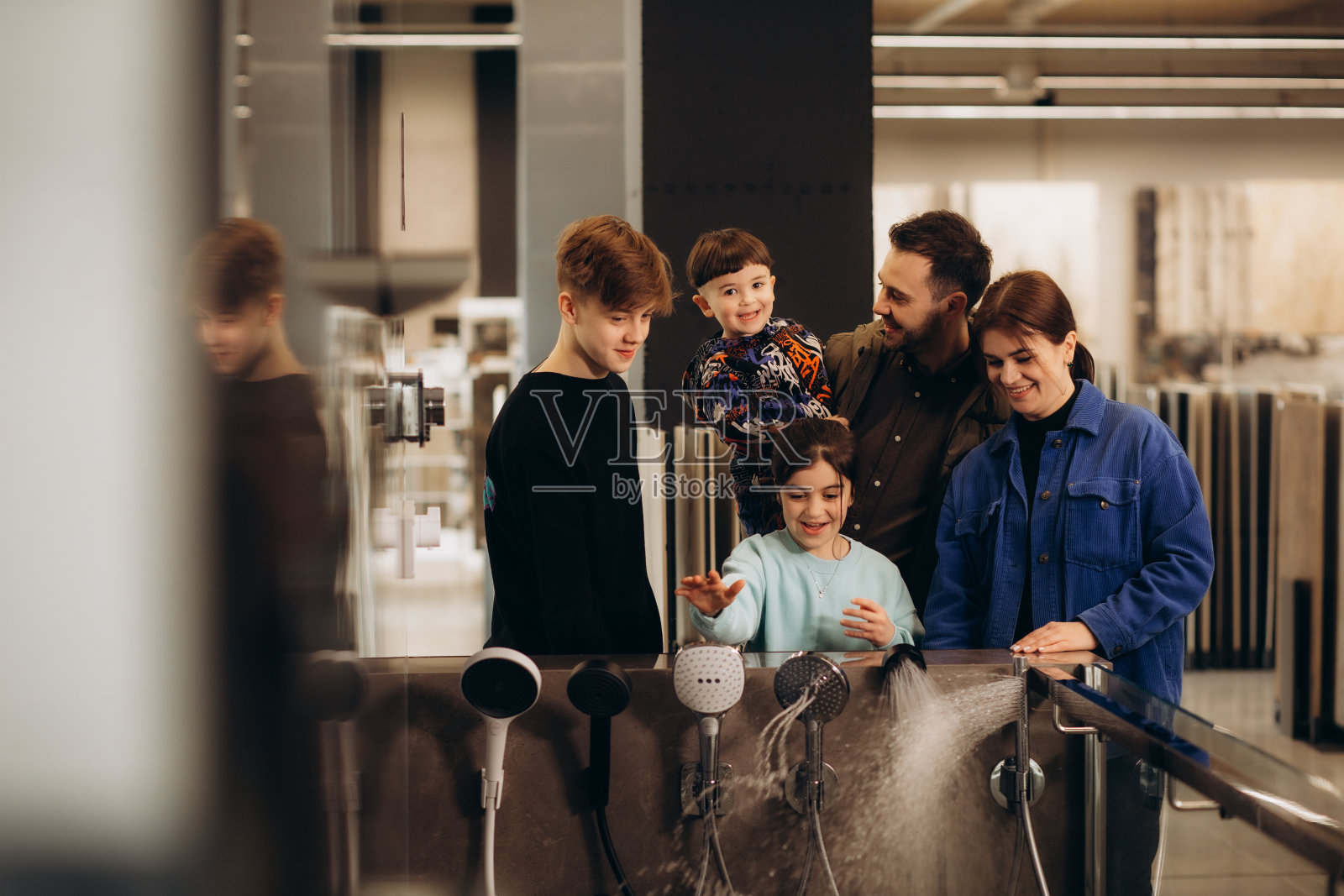 一个年轻的大家庭在商店里选择淋浴系统照片摄影图片