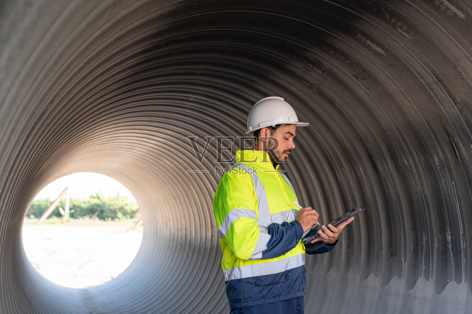 工程师拿着平板检查管道。照片摄影图片