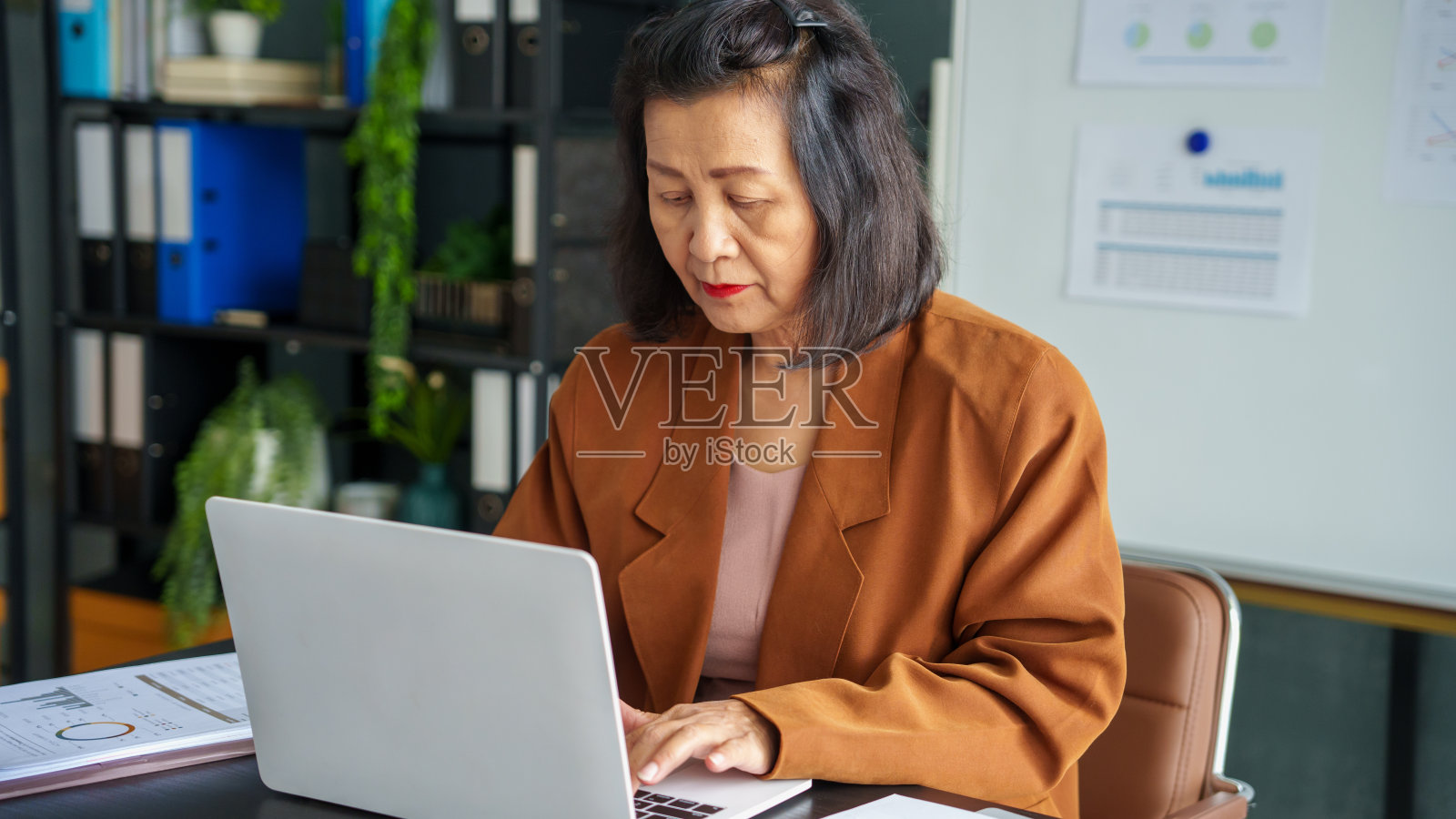 成熟的商业亚洲womanÂ企业家在办公室使用笔记本电脑。60多岁businesswomanÂ拥有科技的亚洲资深女性照片摄影图片