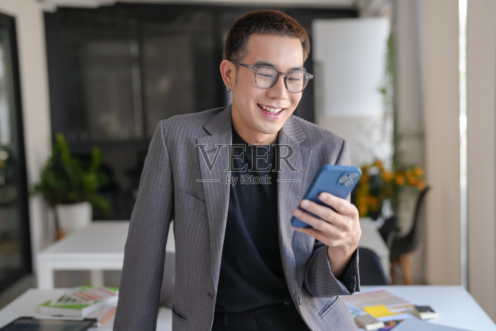 微笑confidentÂ亚洲商人使用smartphoneÂ手机上瘾者花时间查看新闻技术电子商务的概念。照片摄影图片