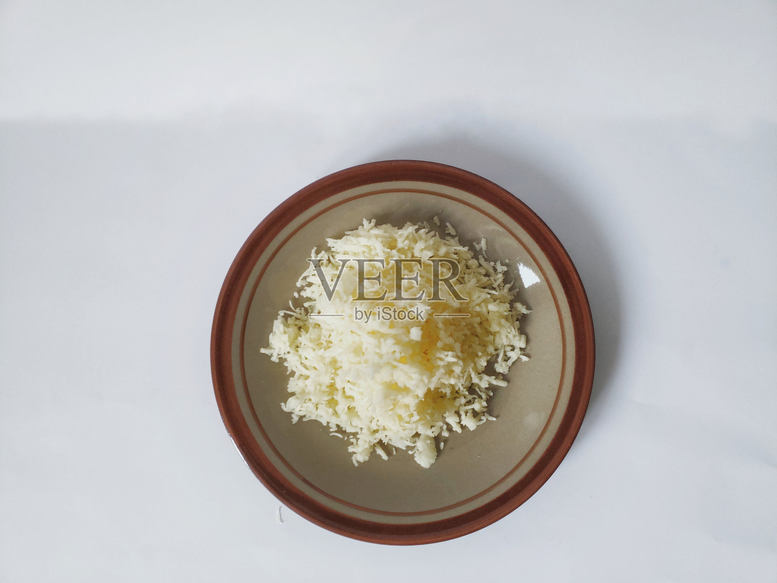 一盘磨碎的奶酪被隔离在白色背景中的特写照片摄影图片