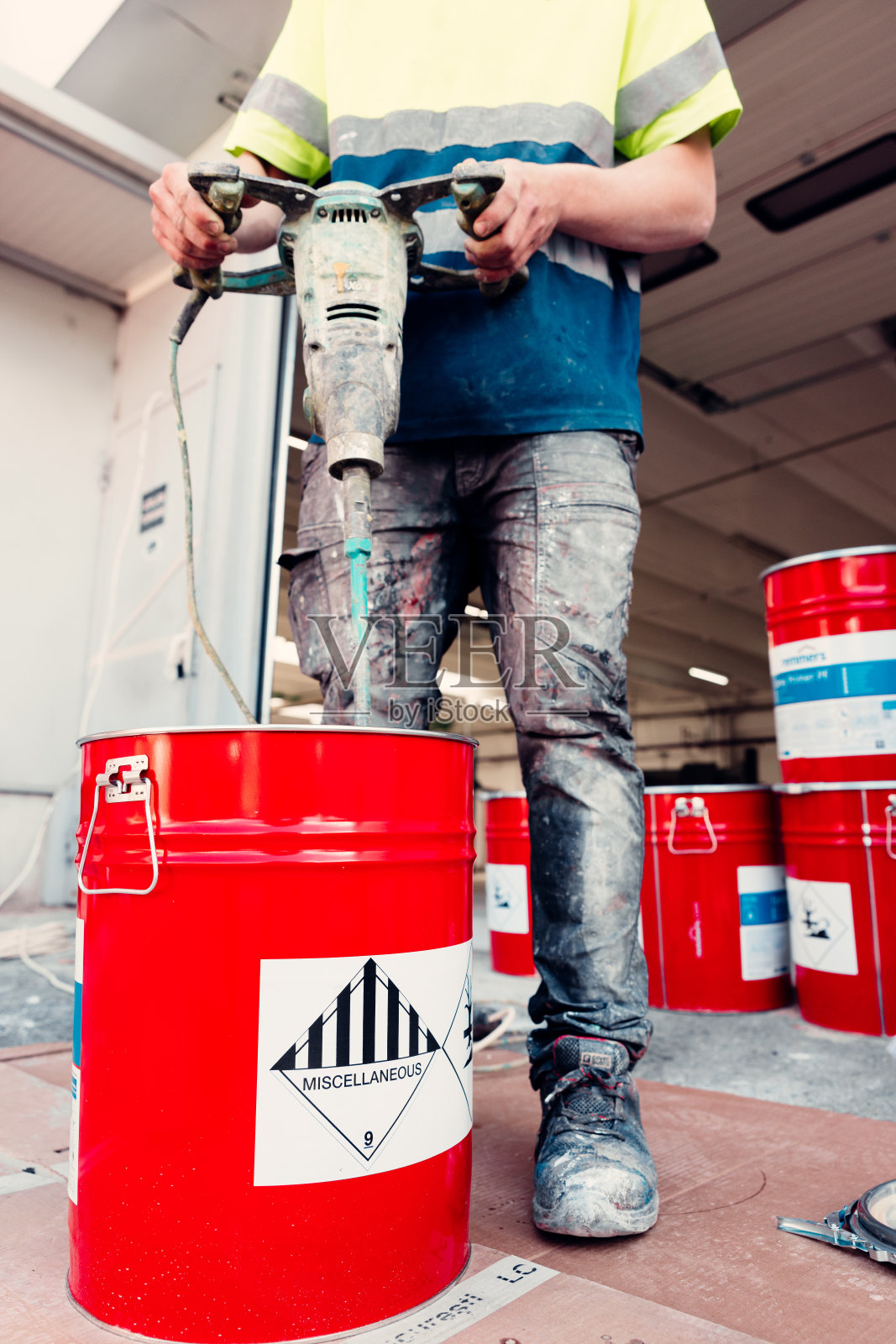 建筑工人在桶里搅拌环氧树脂照片摄影图片