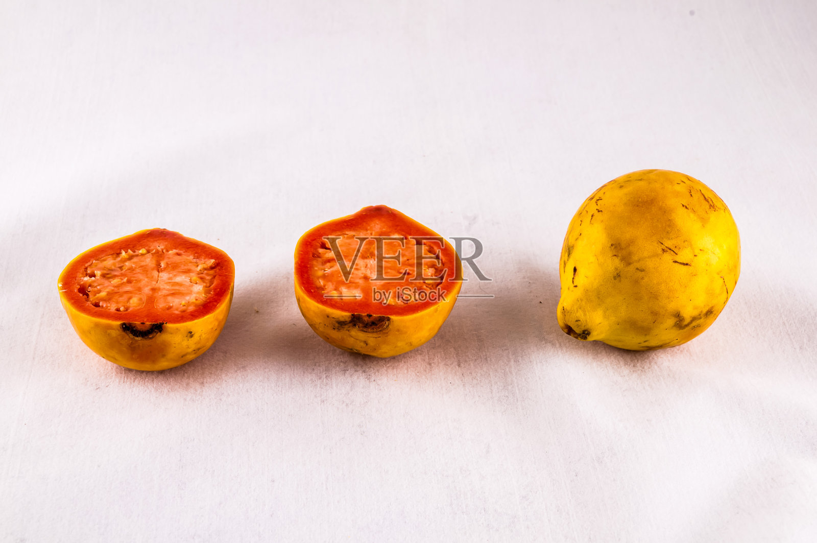 三个水果，其中一个是西红柿，在白色的背景上显示照片摄影图片