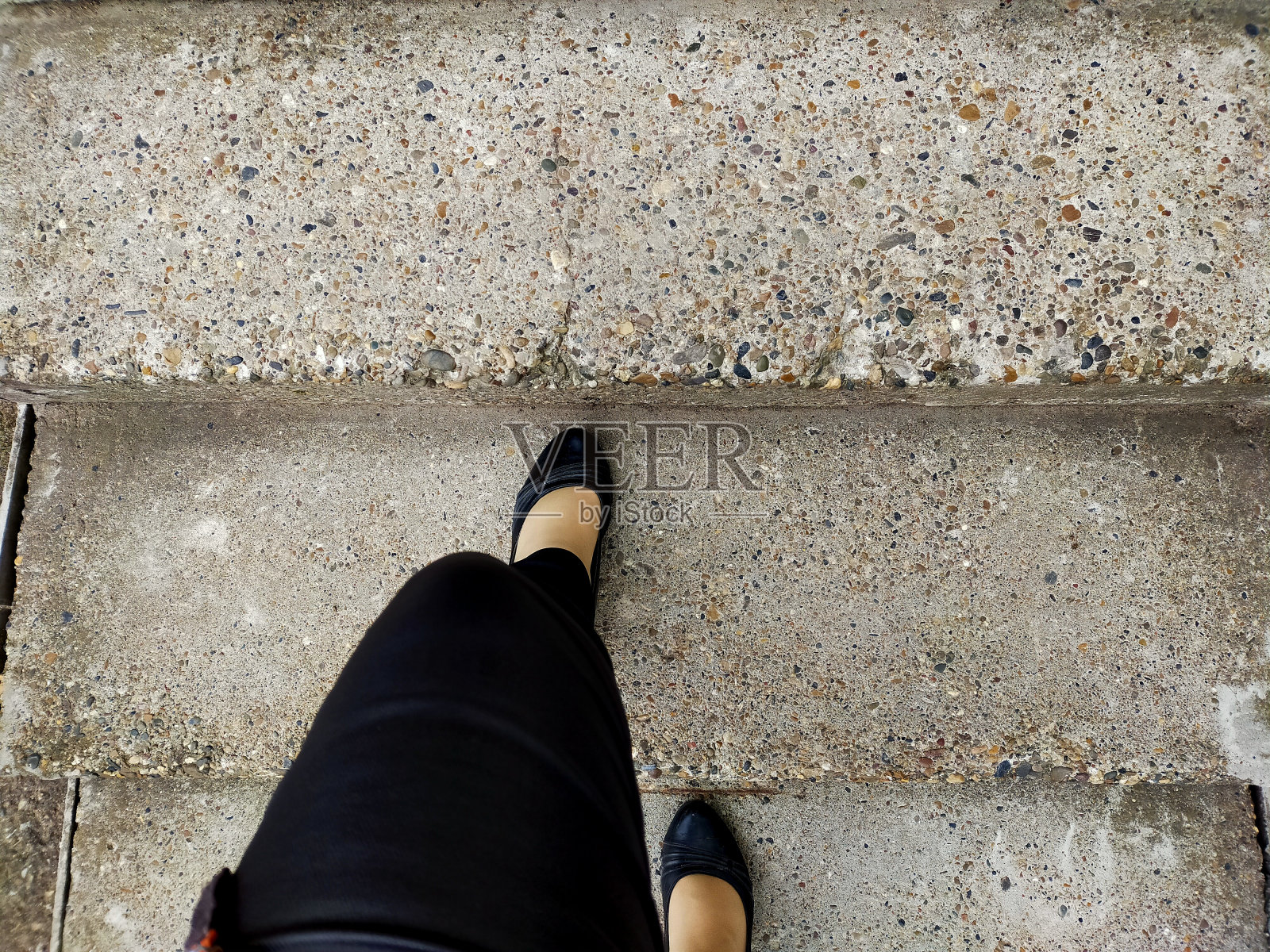 穿着黑色紧身裤和黑色鞋子的女人们爬上不平坦的混凝土楼梯。女性抱负的概念和通往未来的途径载体。照片摄影图片