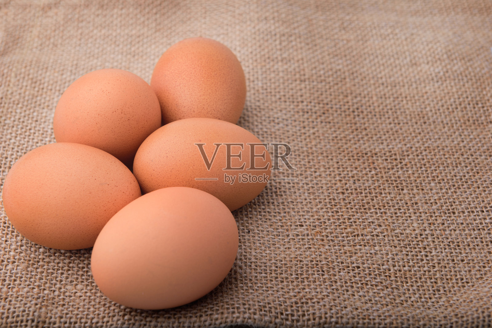 五个棕色的蛋躺在棕色的表面上。照片摄影图片