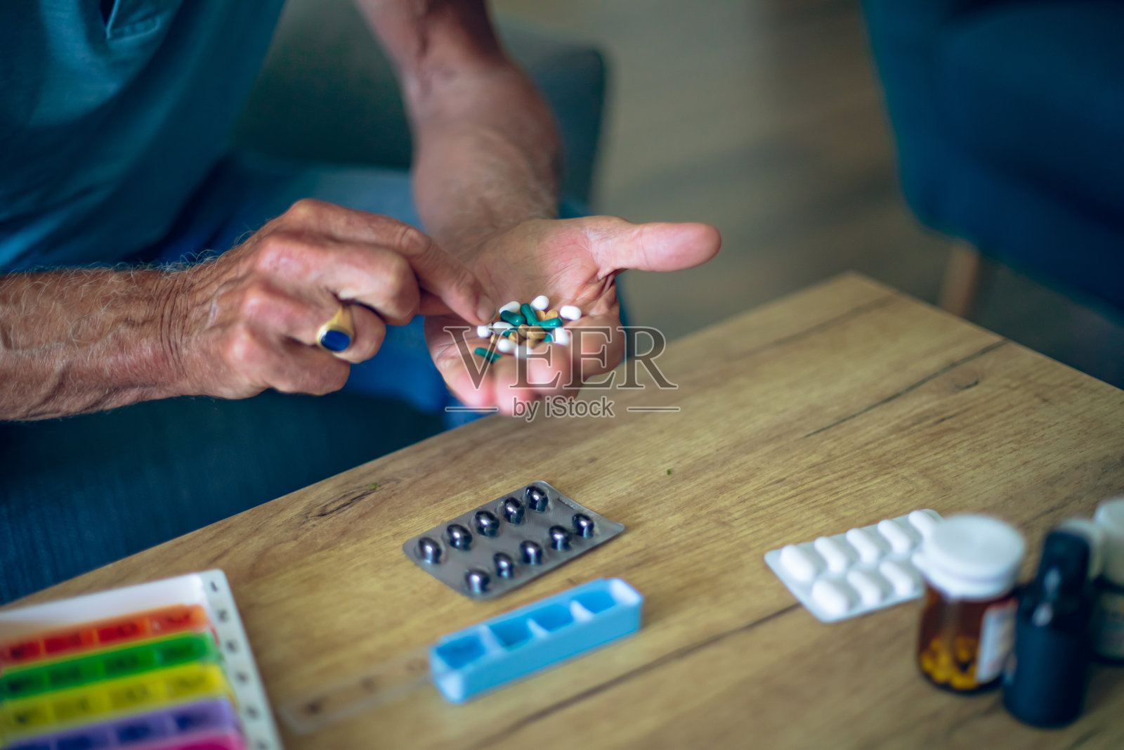 桌上和一个老人手里都有药品照片摄影图片