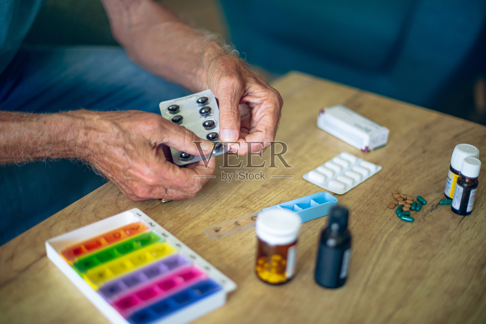 桌上和一个老人手里都有药品照片摄影图片
