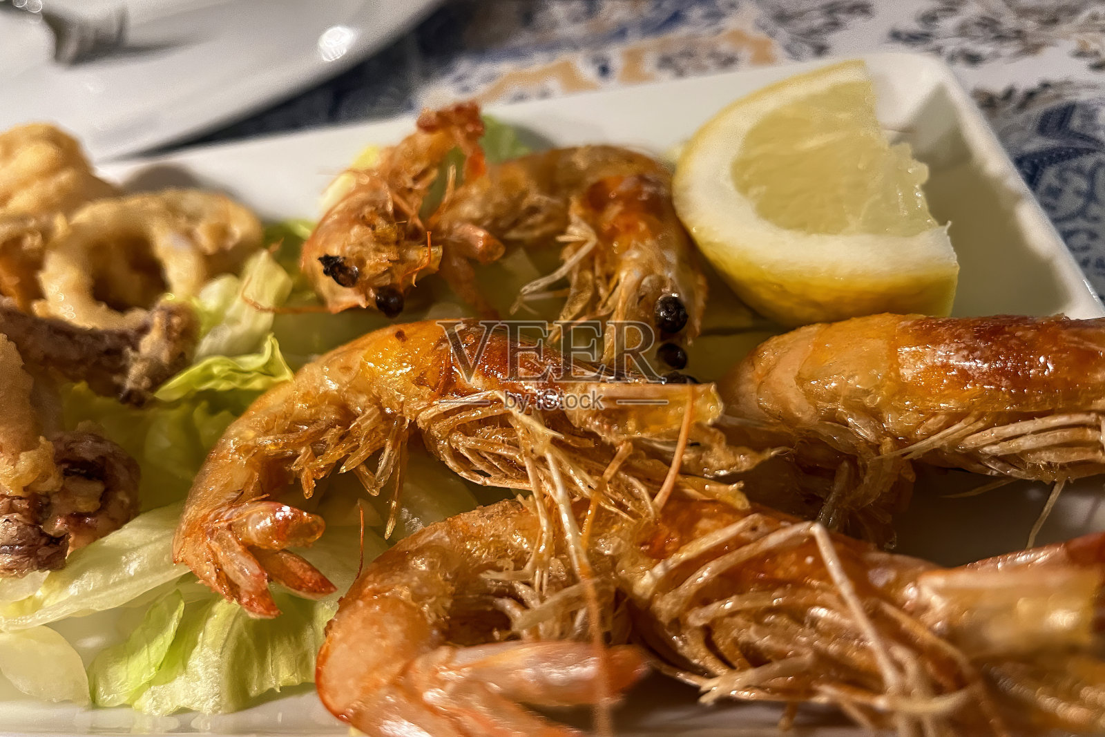 意大利餐厅里的烤虾配上柠檬、大蒜和白酱。海鲜照片摄影图片