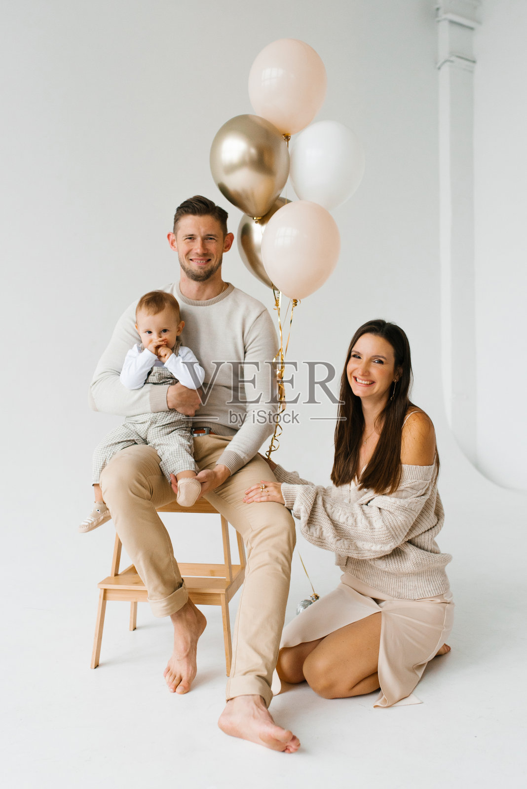 一个白人家庭的肖像，有一个一岁的孩子和气球照片摄影图片