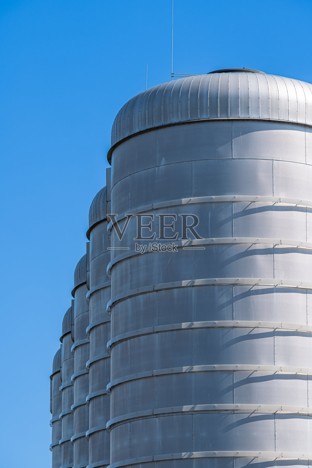 在晴朗的天空下，从低角度看一排排的储油罐照片摄影图片