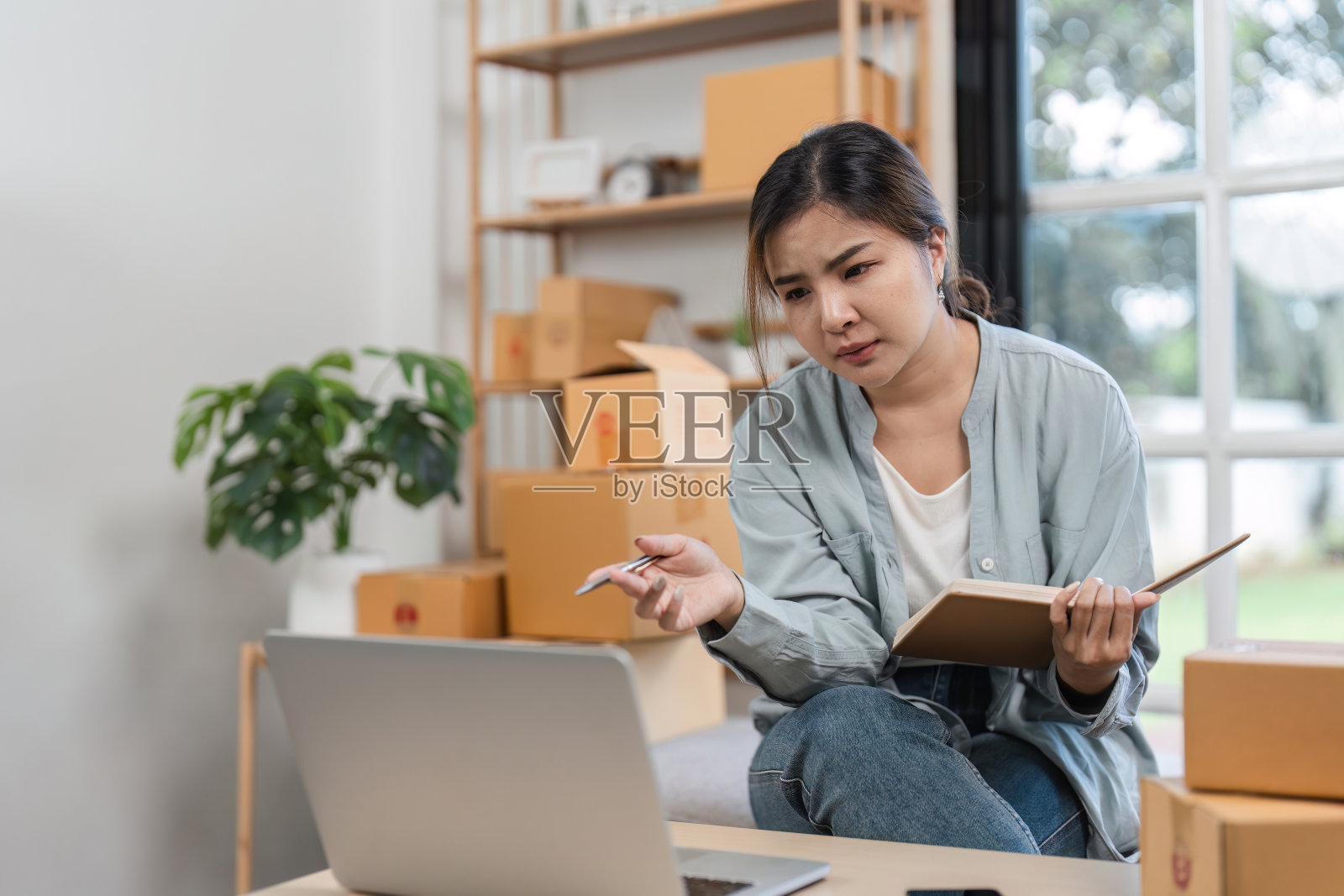 年轻女子在家里销售产品时对网上销售系统感到紧张照片摄影图片
