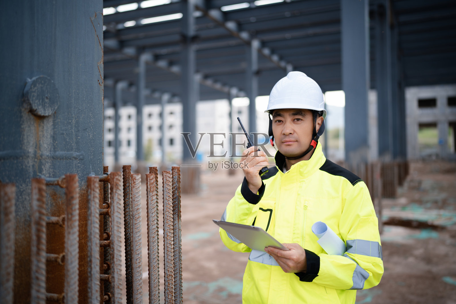 中年男性建筑技术人员，头戴工作帽，身穿防护服，在建筑工地工作照片摄影图片