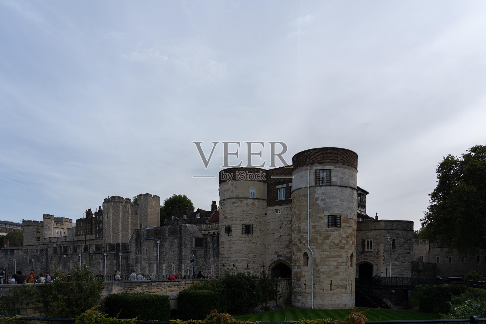 英国伦敦，一座有入口的石头堡垒，四周环绕着绿色植物。照片摄影图片