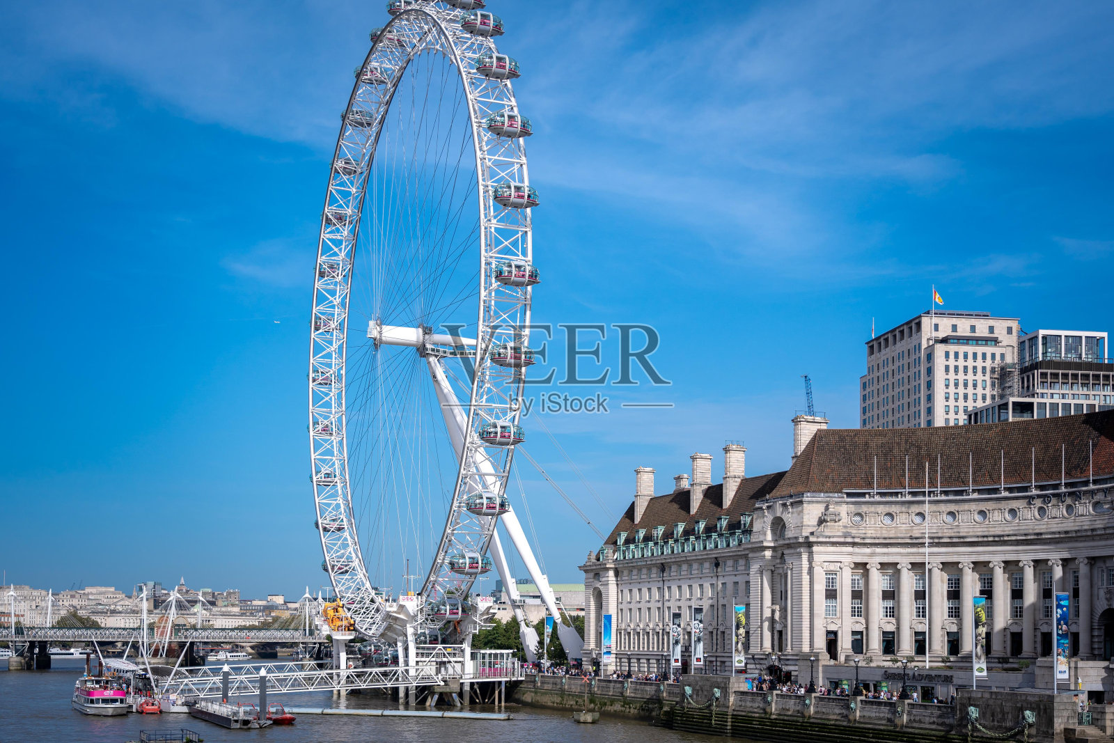 伦敦眼摩天轮，泰晤士河和美丽的蓝天。照片摄影图片