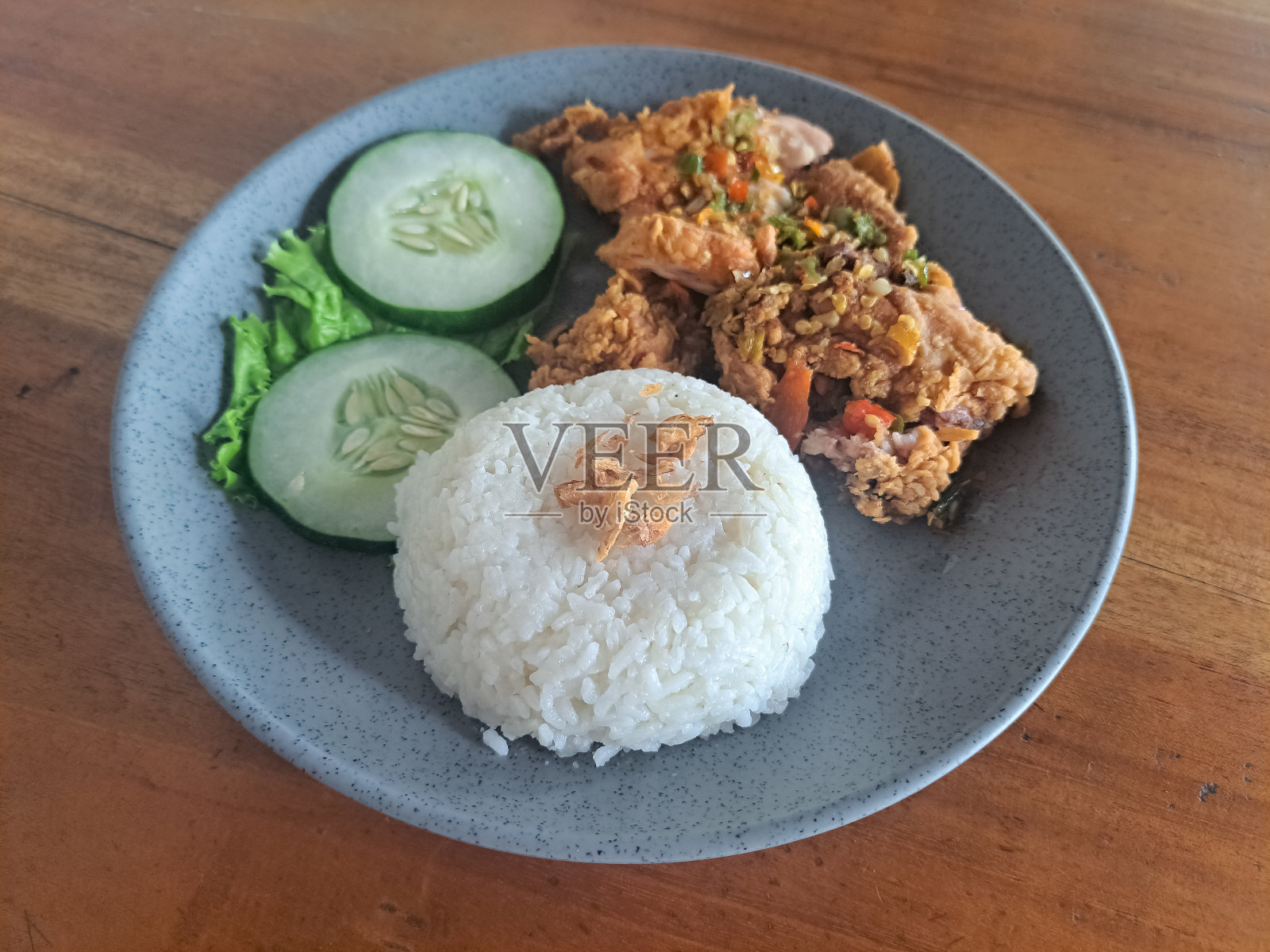 美味的无骨鸡腿配辣椒酱。配上油炸洋葱、黄瓜和生菜。食品菜单。照片摄影图片