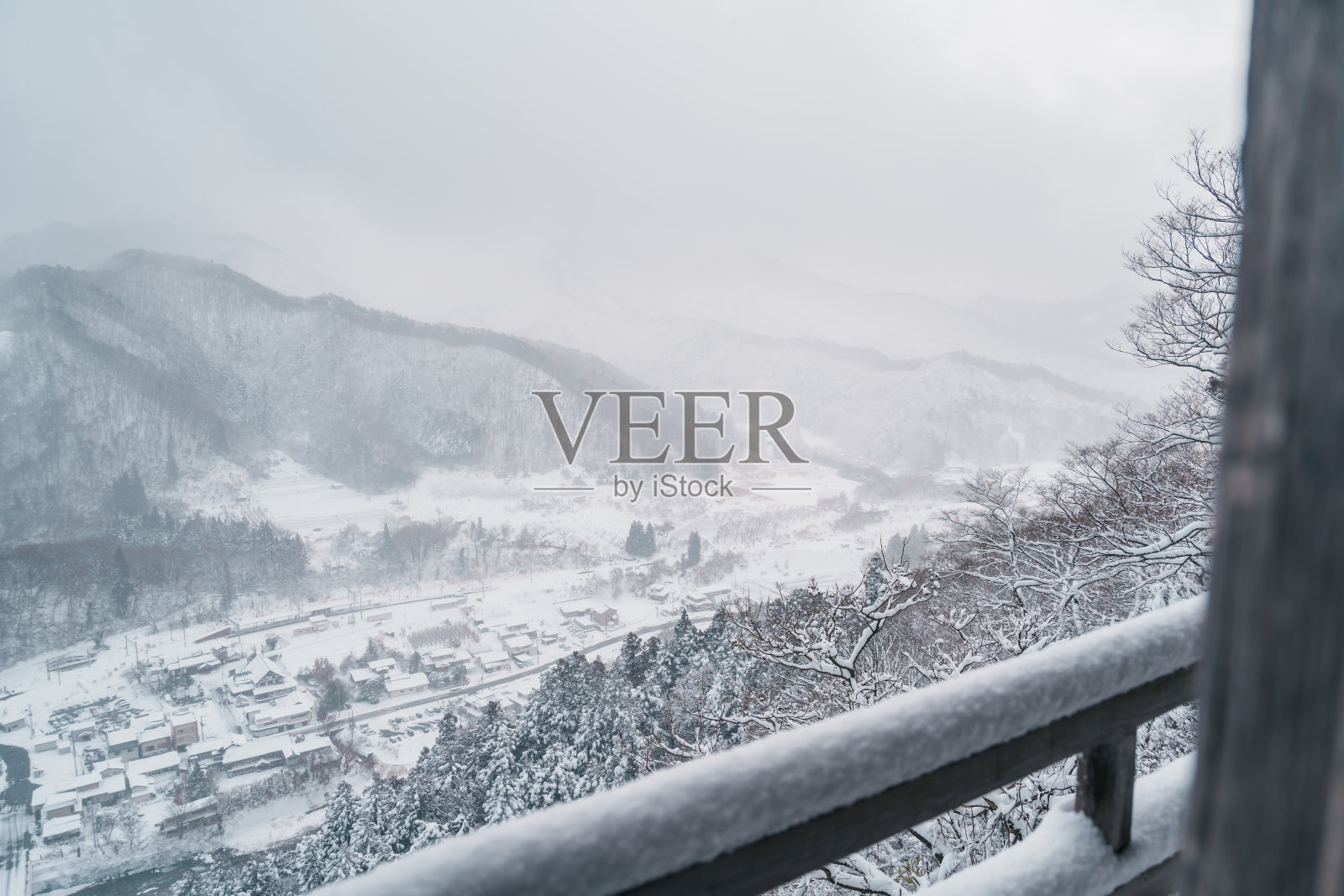 山寺是位于日本东北部山形县山形市的Risshakuji佛教寺庙的俗称。从山寺的山上看冬天下雪的村庄照片摄影图片