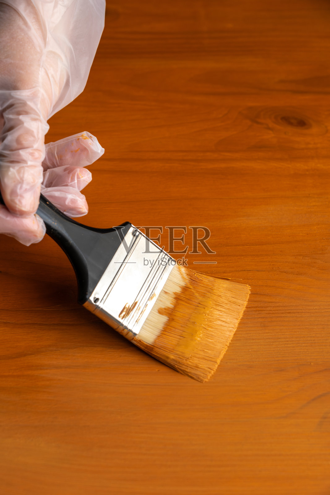 用棕色珐琅漆桌子，用手刷近距离，用棕色染料漆木制家具的过程照片摄影图片