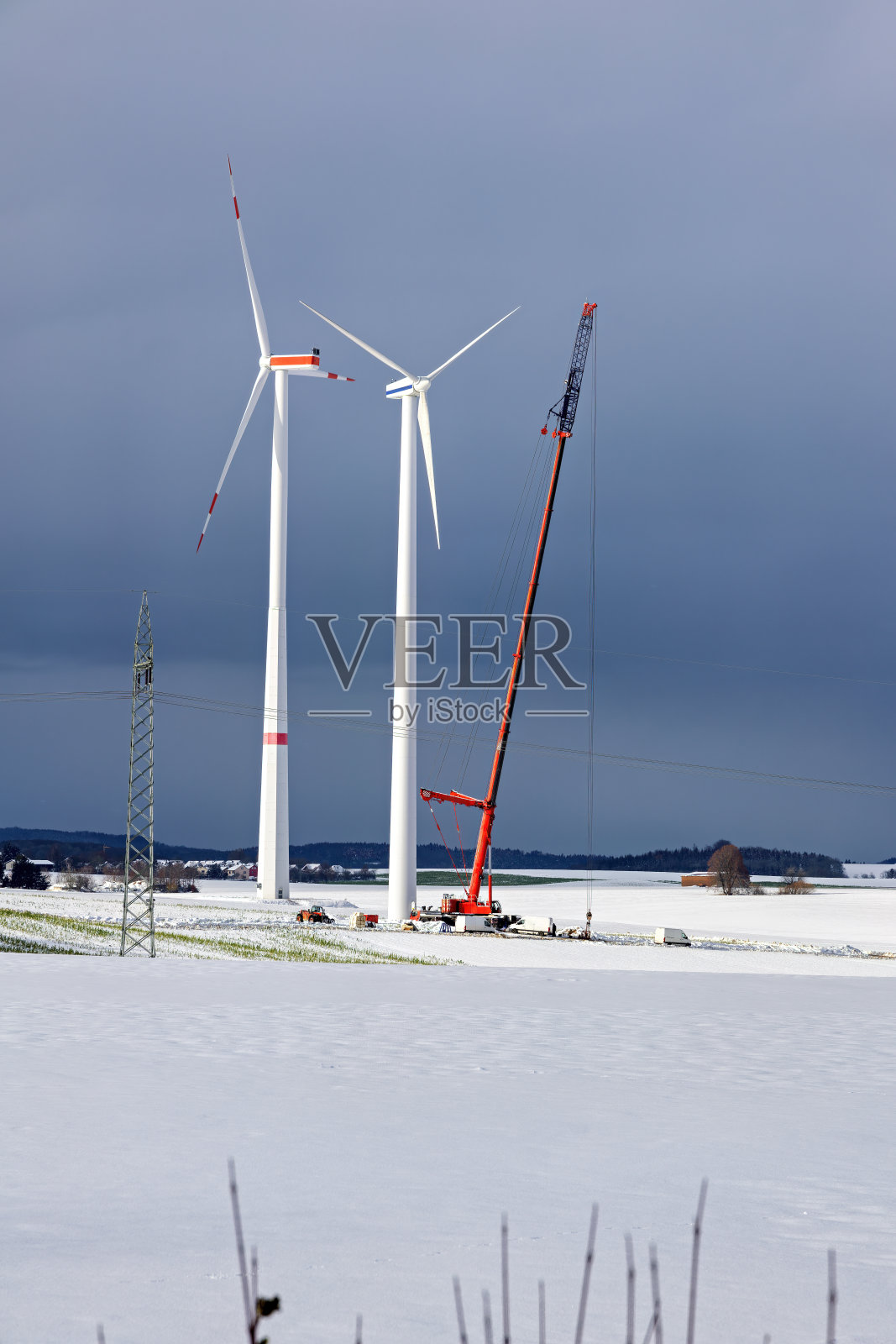 冬天的雪和建筑工人的机器安装风力涡轮机照片摄影图片