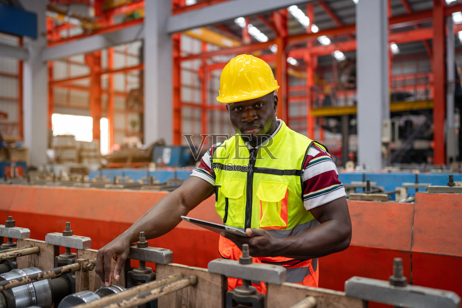 男性工程师或工厂工人使用片剂监控生产输送机。照片摄影图片