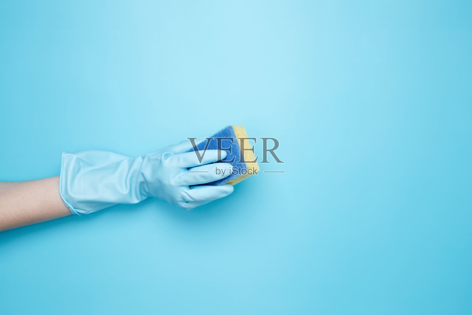 戴着橡胶手套的女人手里拿着黄色的洗碗海绵。打扫屋子。本空间照片摄影图片