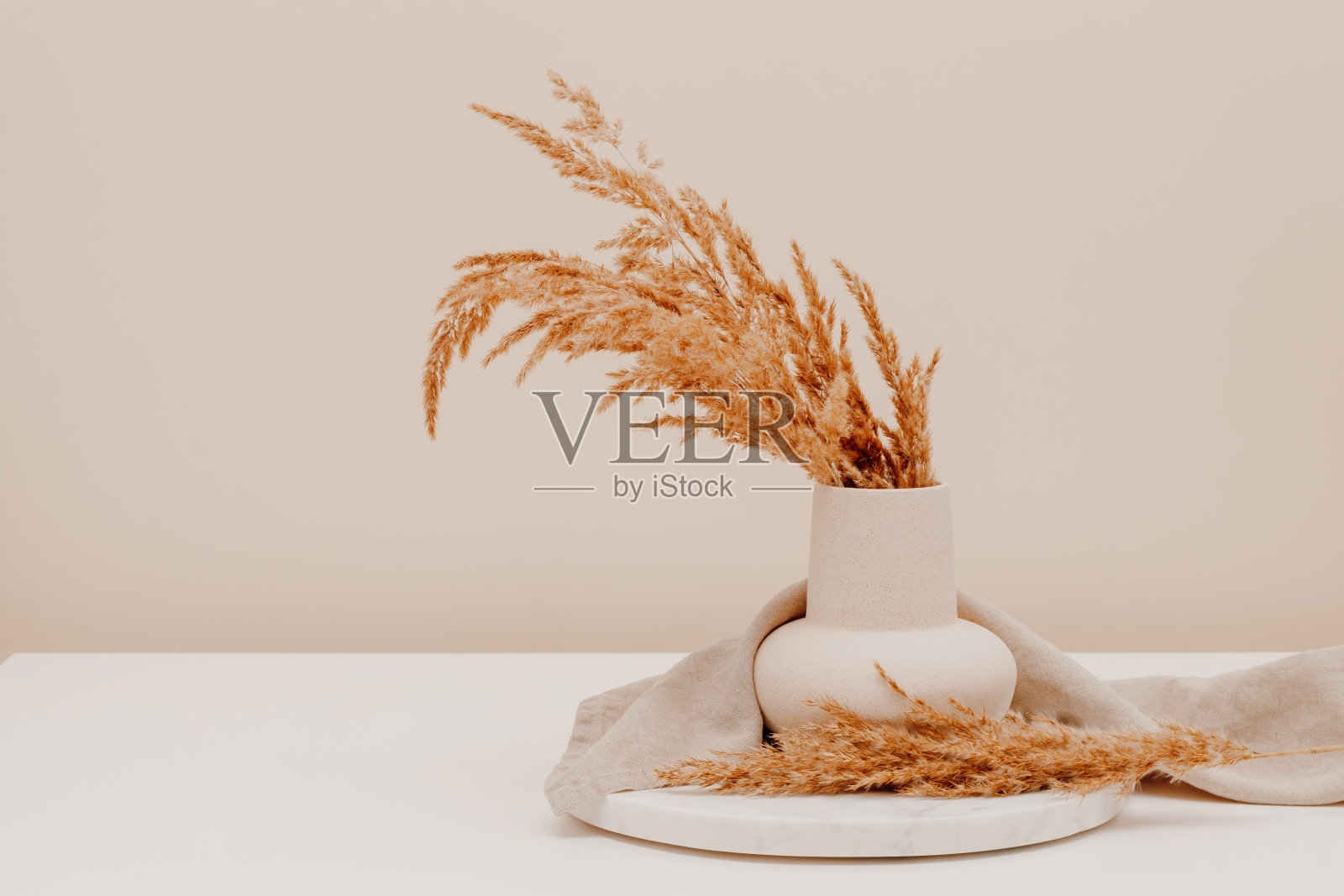 美学静物与花瓶在大理石托盘与潘帕斯草花束在桌子上照片摄影图片