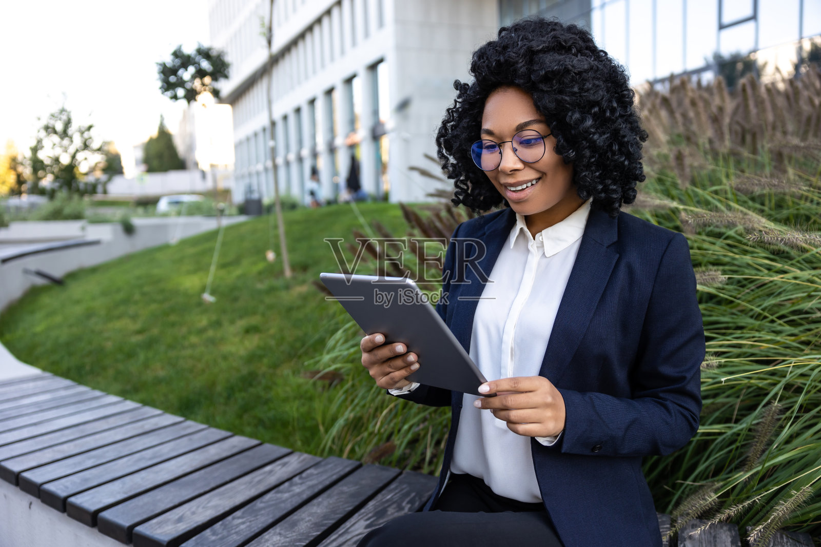 黑发女商人站在办公区手里拿着平板电脑照片摄影图片