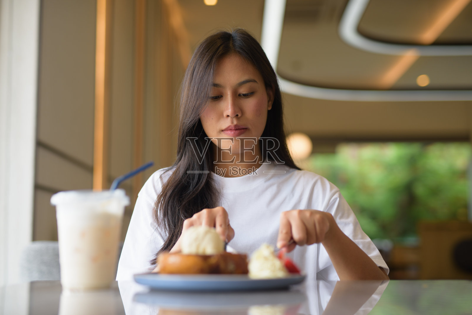年轻的泰国女子在咖啡店享用甜点照片摄影图片