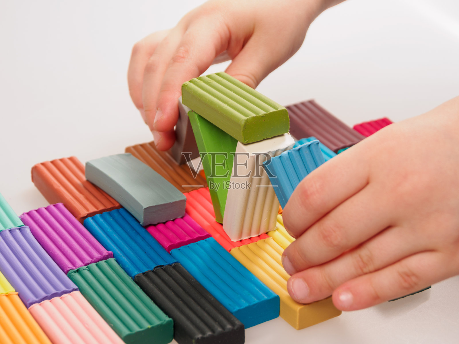 孩子手里拿着鲜亮的塑料粘土，质地柔软，色彩丰富照片摄影图片